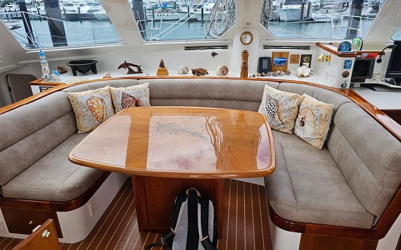 Luxurious yacht interior with cushioned seating, wooden table, and nautical decor, Custom Given1500, 1998.
