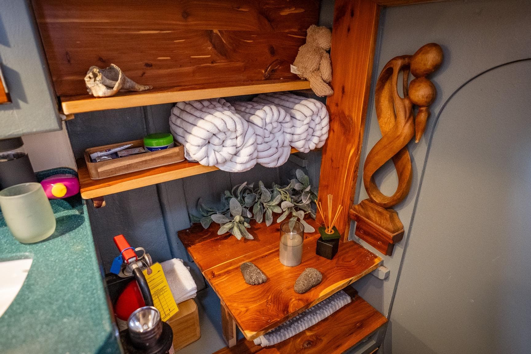 Cozy wooden shelves with decor and essentials in a 1973 Alan Wright Custom 65 boat.