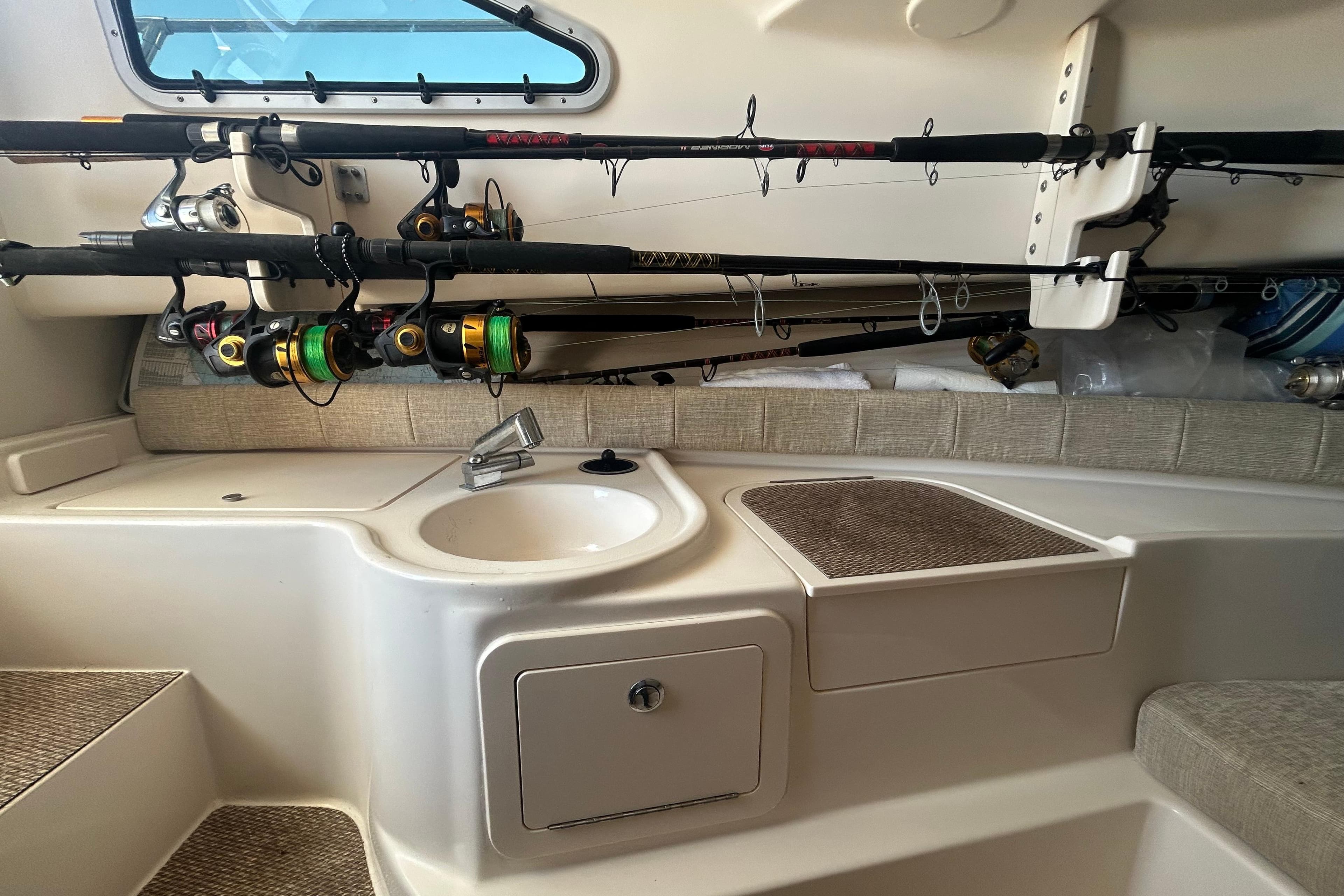 Interior of 2021 Grady-White Gulfstream 232 boat with fishing rods and sink.