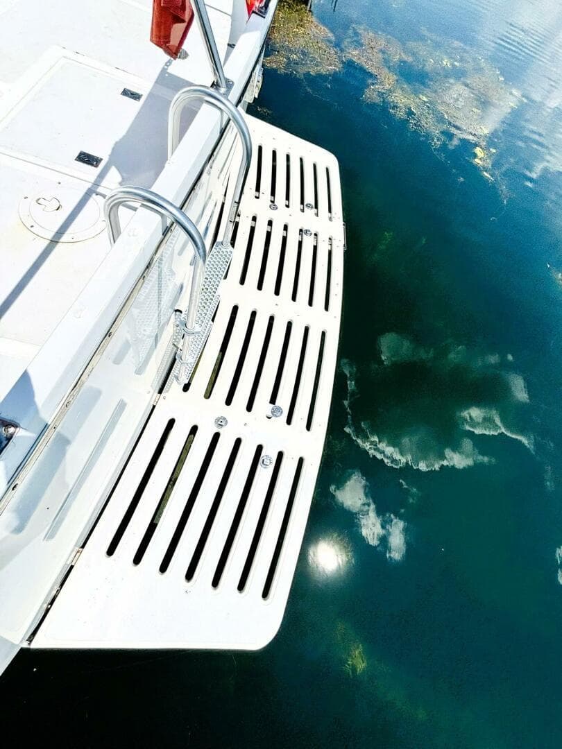 1985 DeFever 40 Offshore swim platform reflecting on calm water.