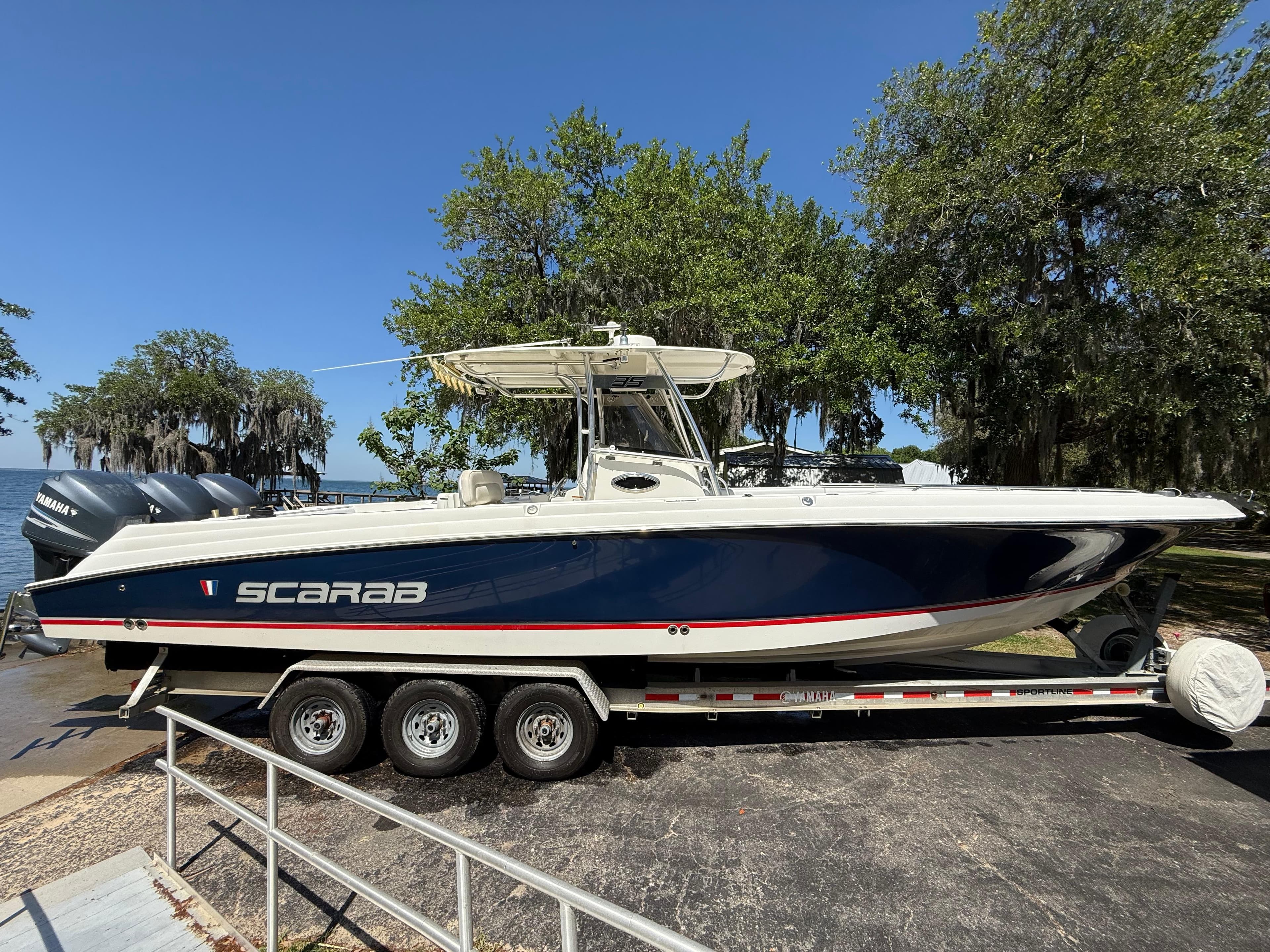 2007 Wellcraft 352 Tournament boat on trailer, blue hull, triple engines, parked outdoors.