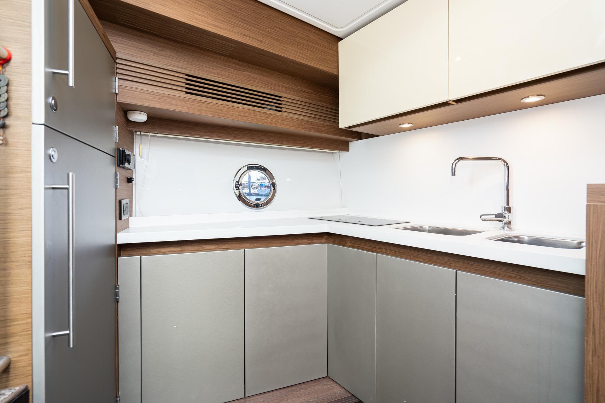 Modern kitchen interior of 2017 Beneteau Gran Turismo 46 yacht, featuring sleek cabinetry and dual sinks.