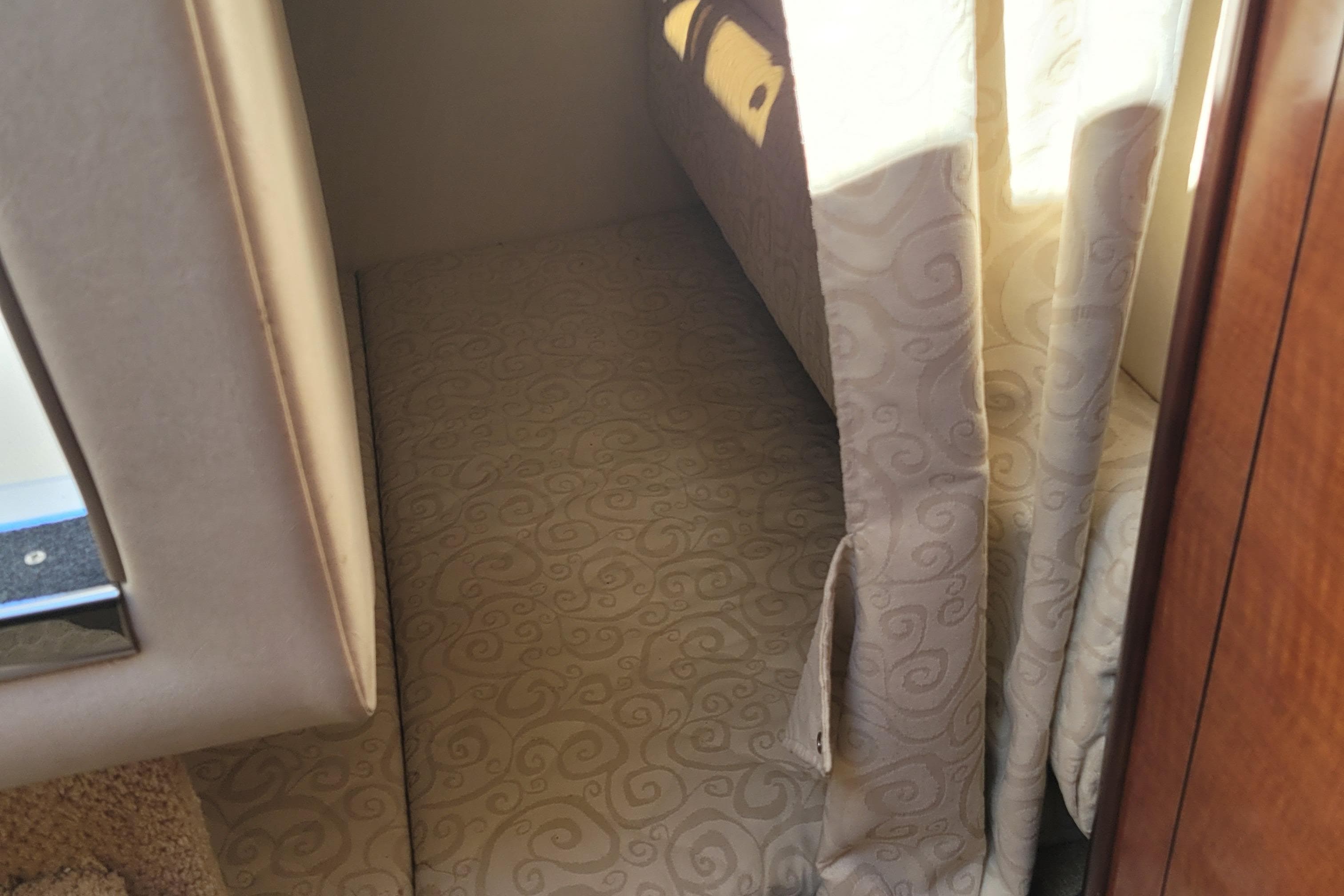 2007 Sea Ray 260 Sundancer cabin interior with patterned upholstery and curtains.