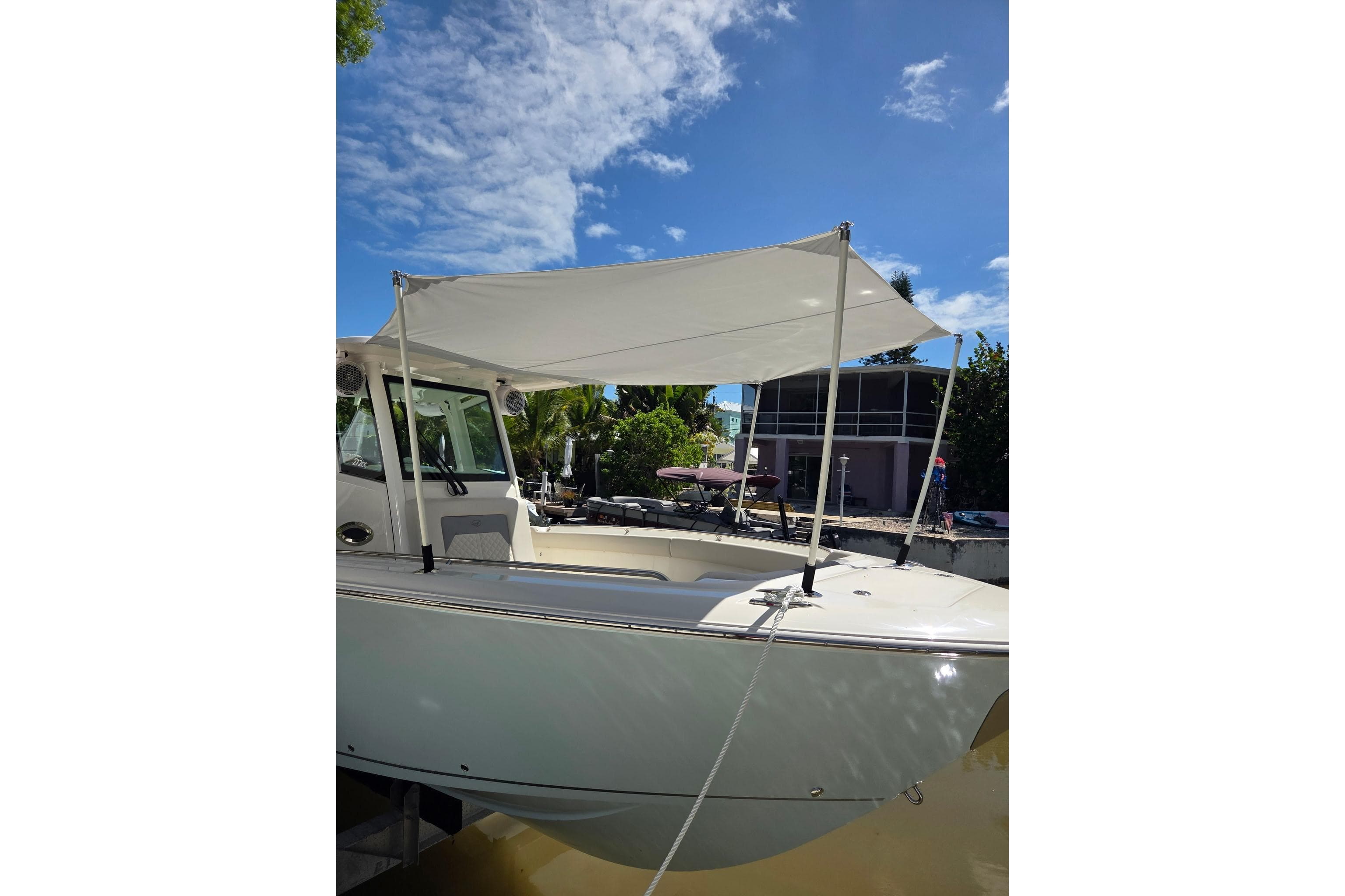 2020 Cobia 350 Center Console boat with canopy, docked under a clear blue sky.