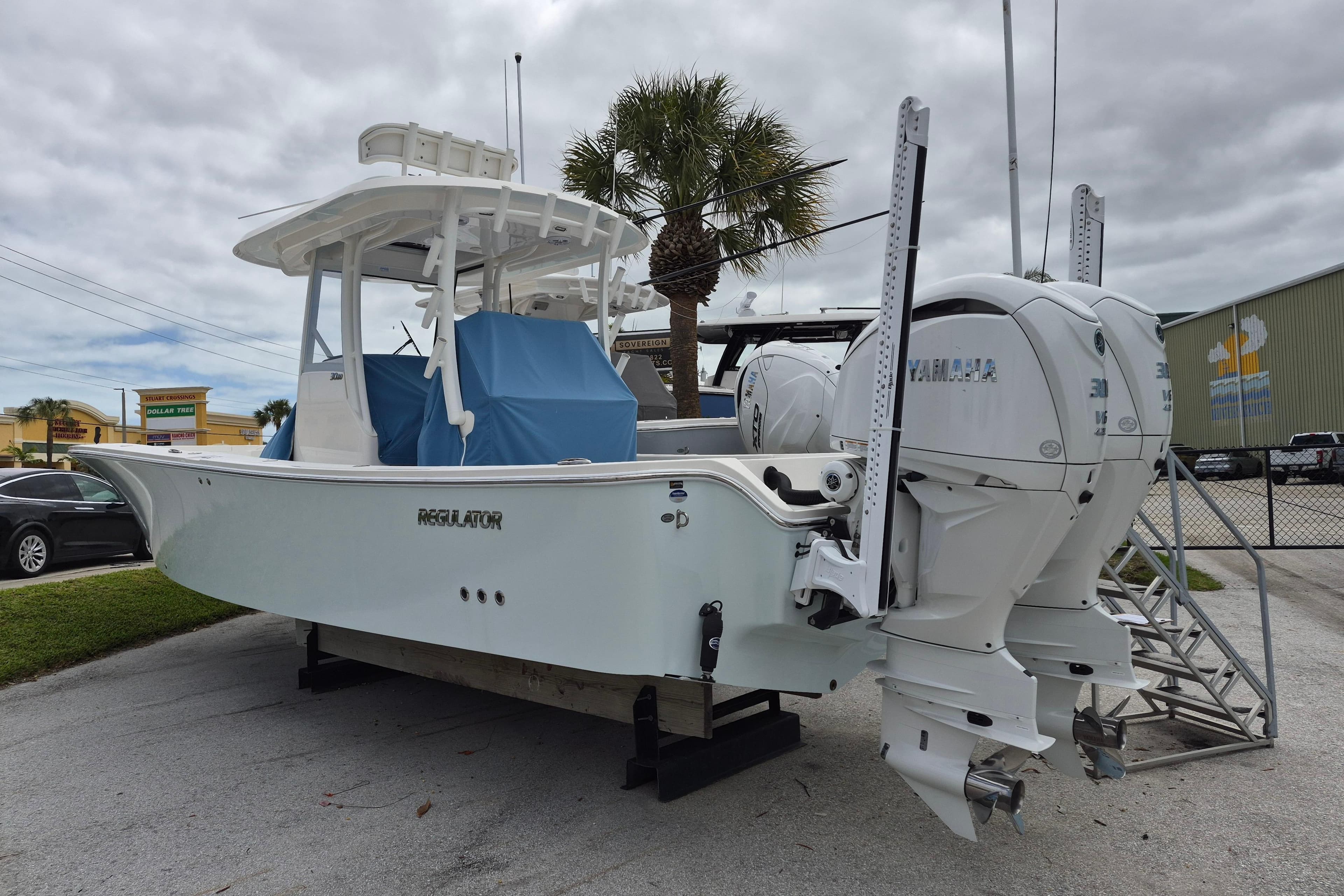 2024 Regulator 30XO boat with twin Yamaha engines, parked outdoors under cloudy skies.