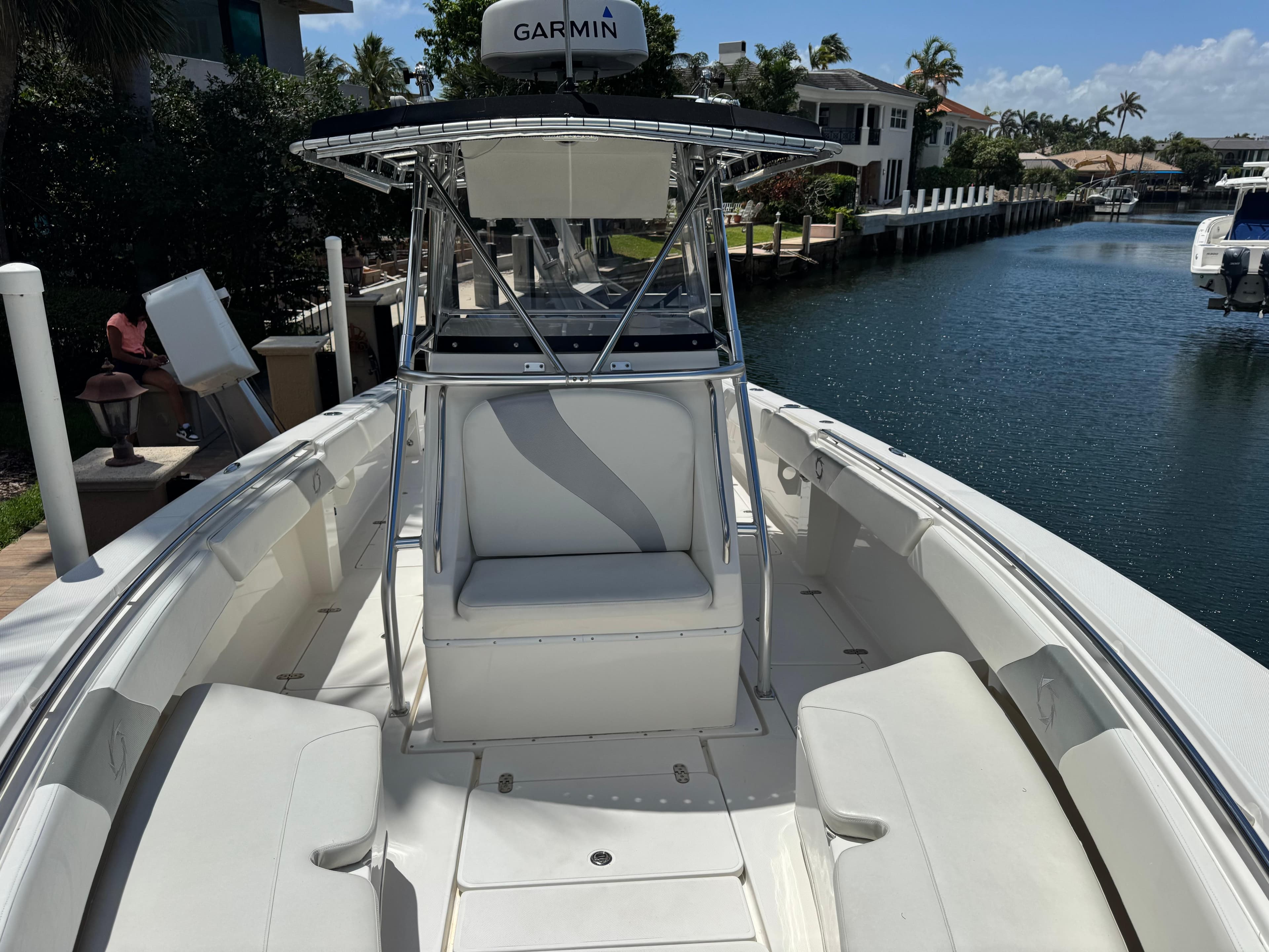 2008 Fountain 34 Center Console boat docked by a canal, featuring spacious seating and Garmin equipment.