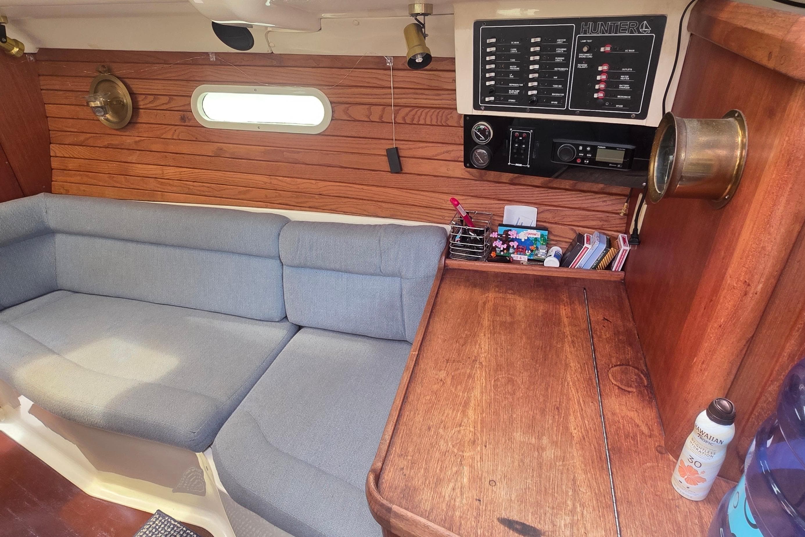 Interior of a 1995 Hunter 336 sailboat with wooden paneling and a cozy seating area.