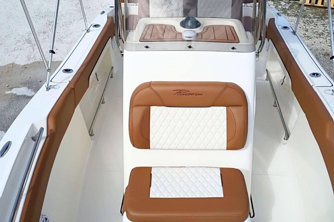 2026 Pioneer 202 Sportfish boat interior with brown and white seating.