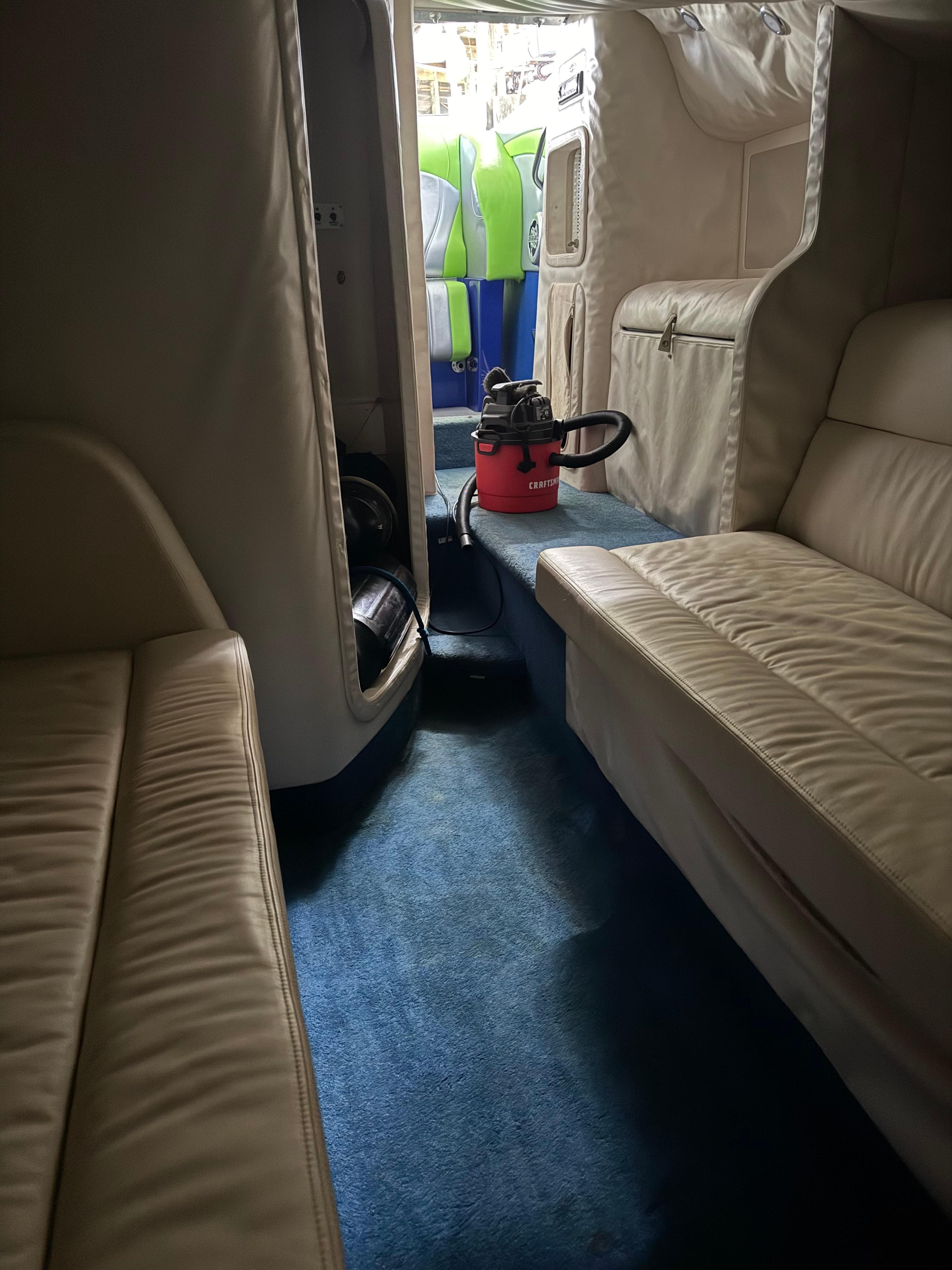 Interior of a 2008 Outerlimits 39 Quattro boat with beige seating and blue carpet.