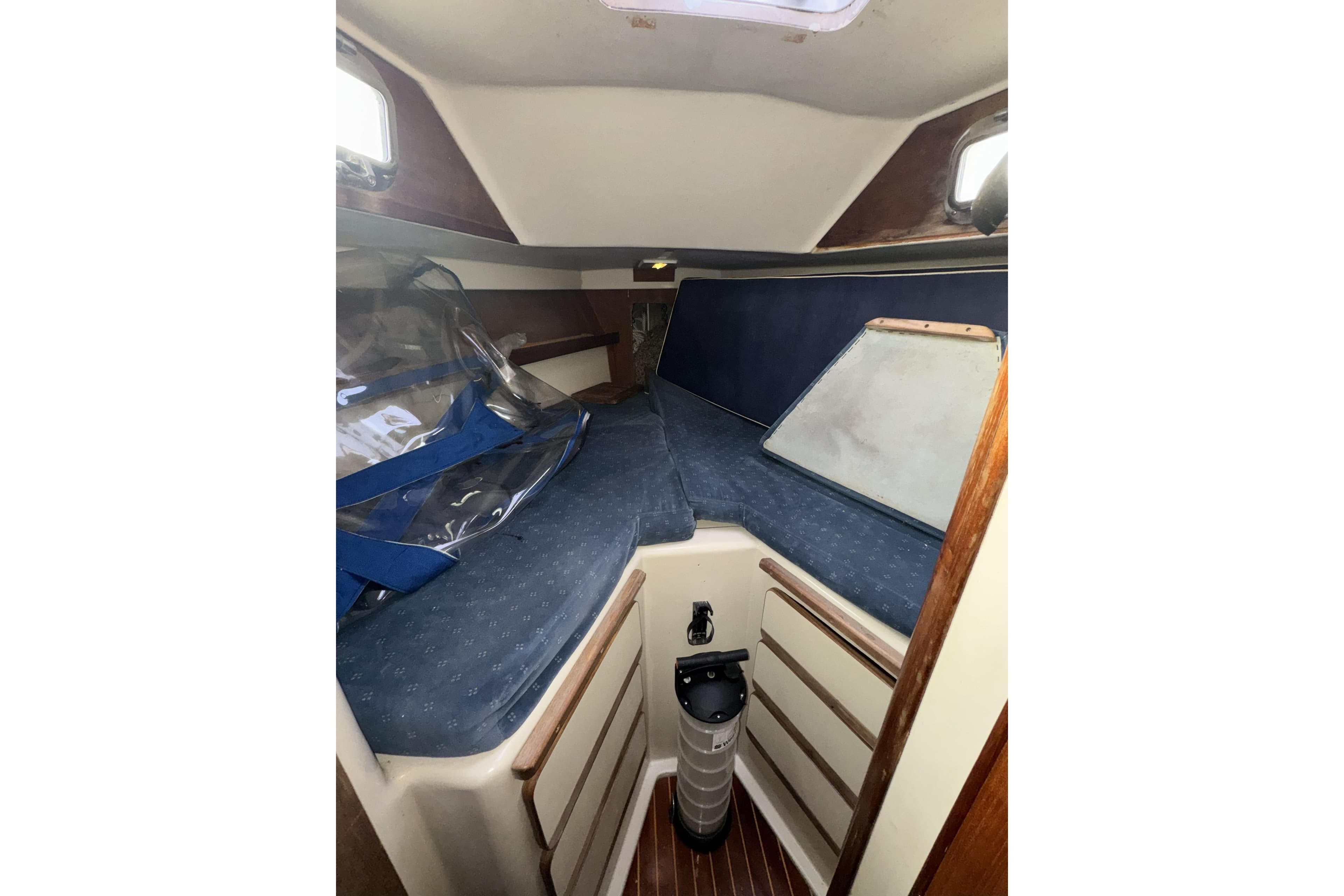 1987 Irwin 38 sailboat cabin interior with blue cushions and wooden accents.