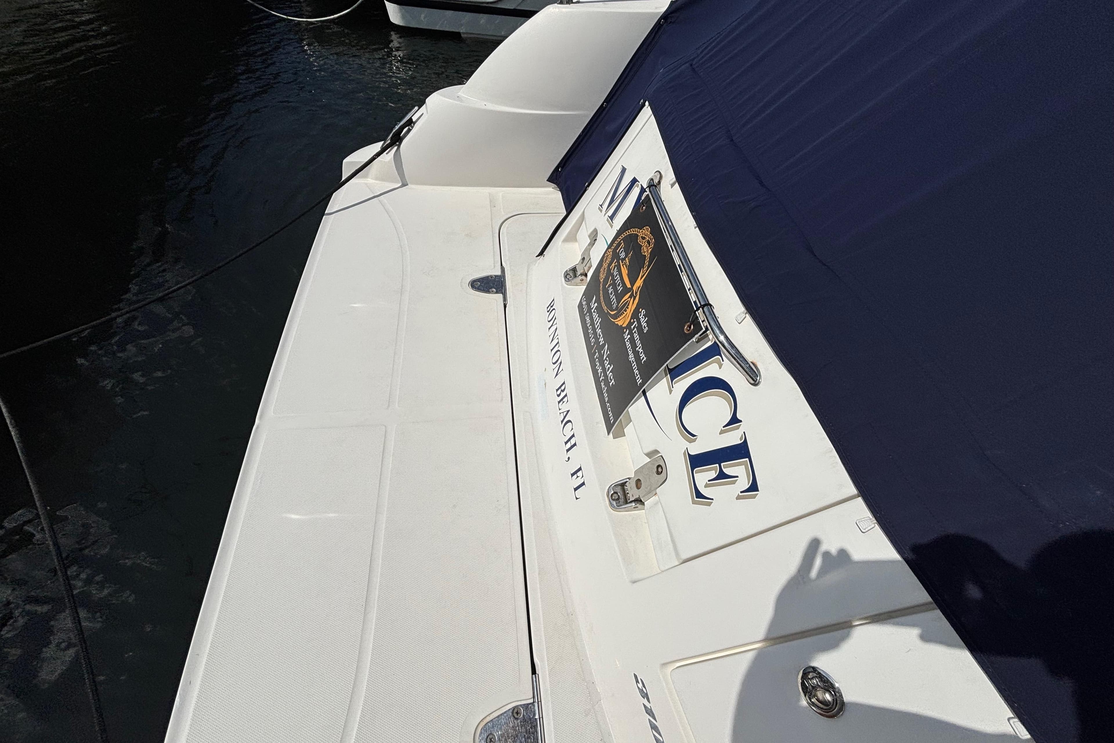 2009 Sea Ray Sundancer 310 boat docked, featuring a white deck and navy cover.