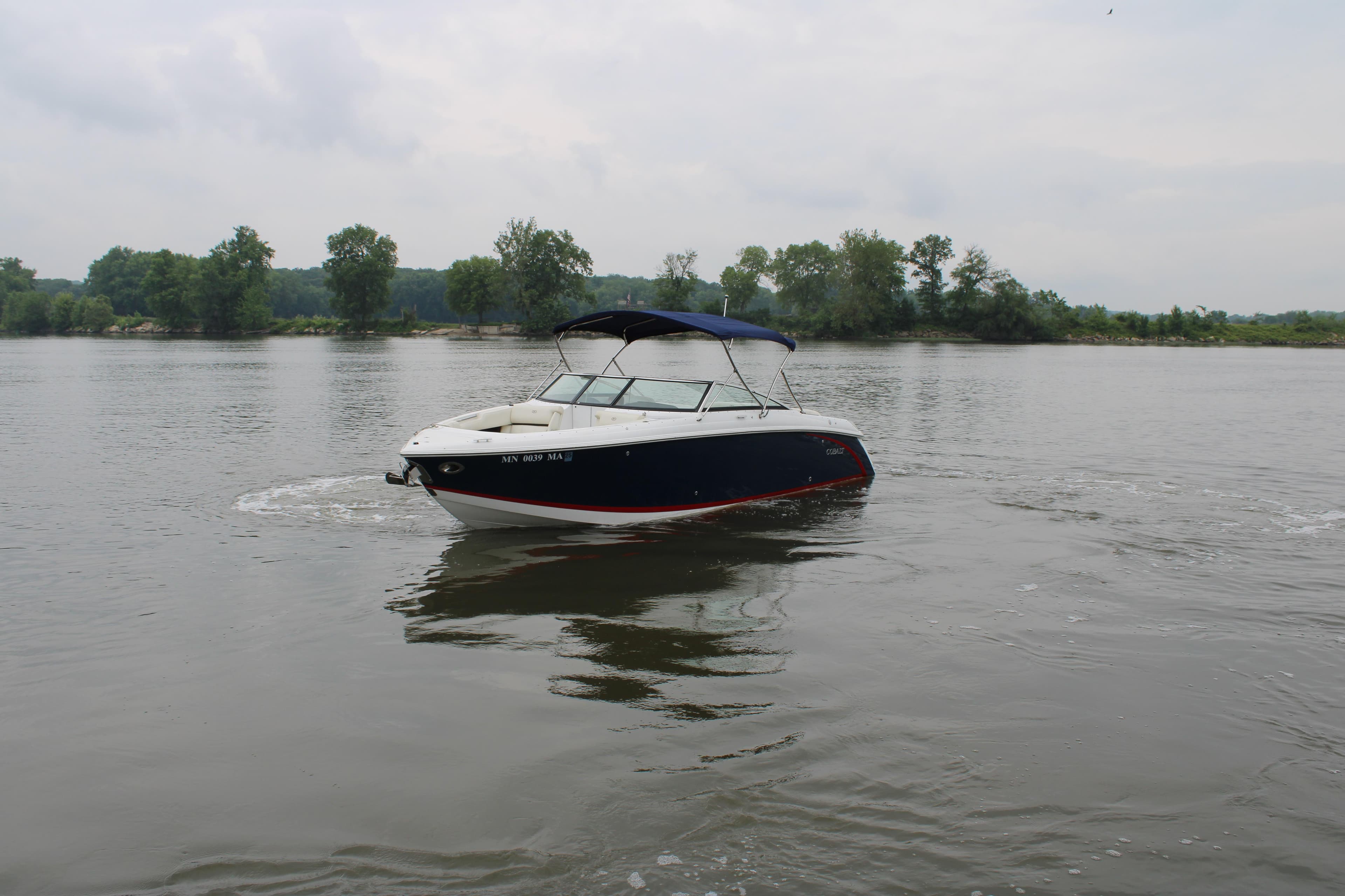 2020 Cobalt R30 boat cruising on a calm lake with trees in the background.