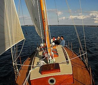 Sailing on a 1929 Herreshoff Fishers Island 31 yacht with passengers on deck.