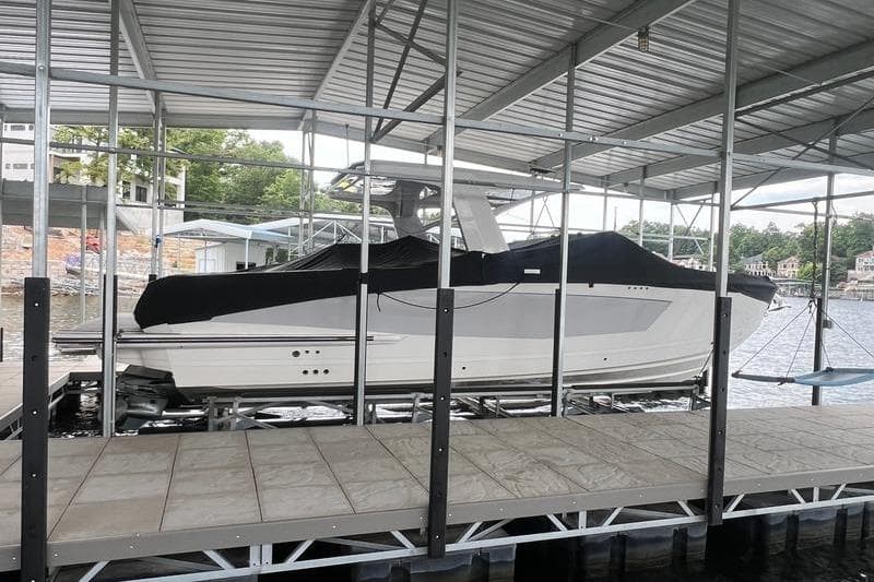 2023 Aviara 36 boat docked under a covered marina, partially covered with a black tarp.