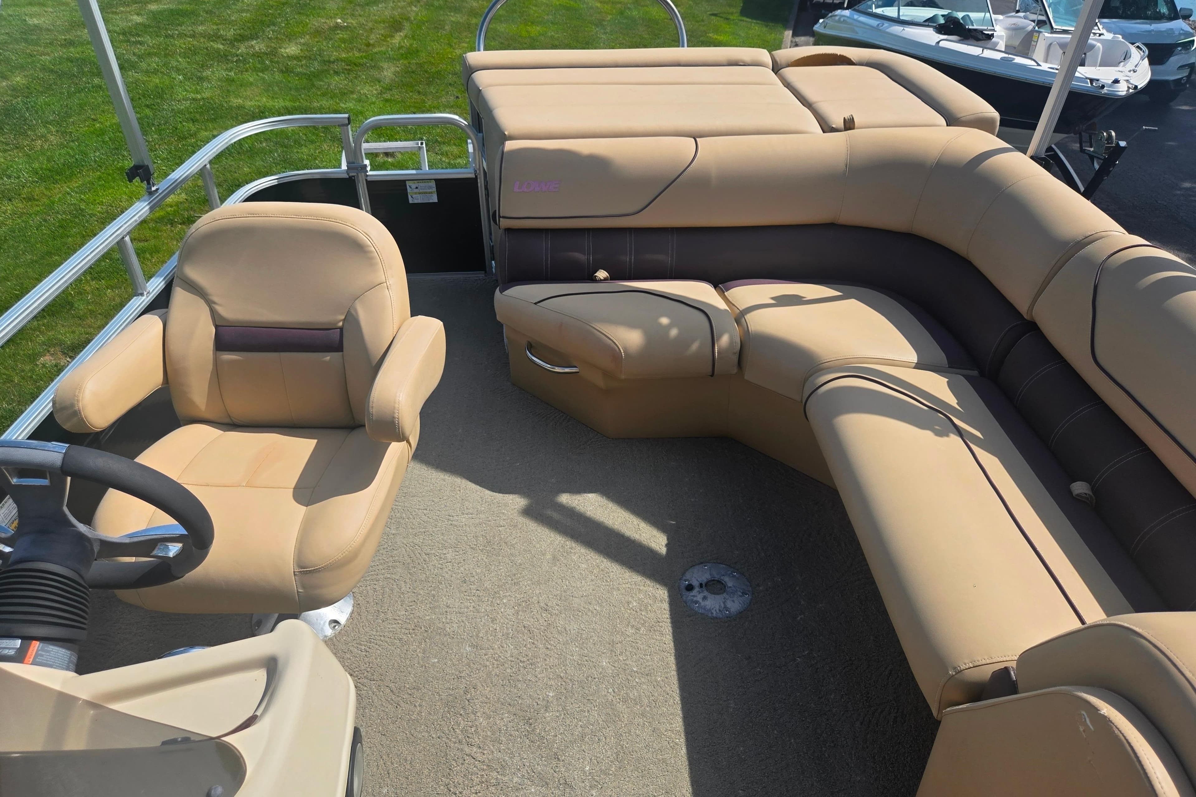 2017 Lowe SS 250 pontoon boat interior with beige seating and steering wheel.