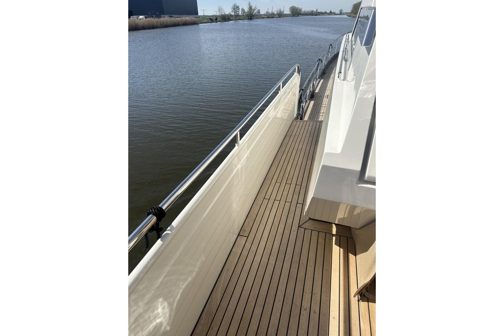 Side deck of 2026 Linssen Grand Sturdy 550 Variotop yacht on calm water.