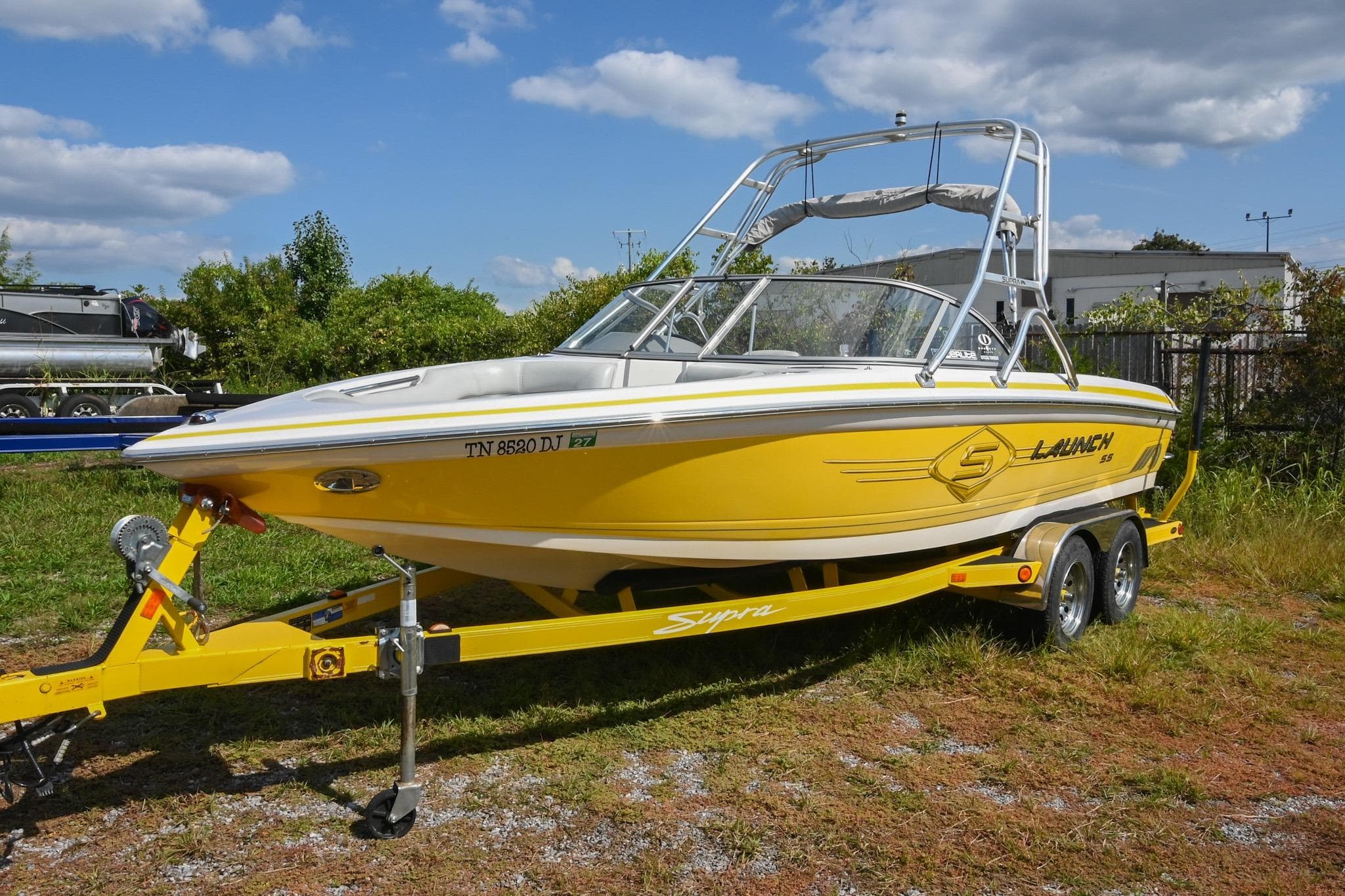 2004 Supra Launch SS boat in vibrant yellow on a matching trailer.