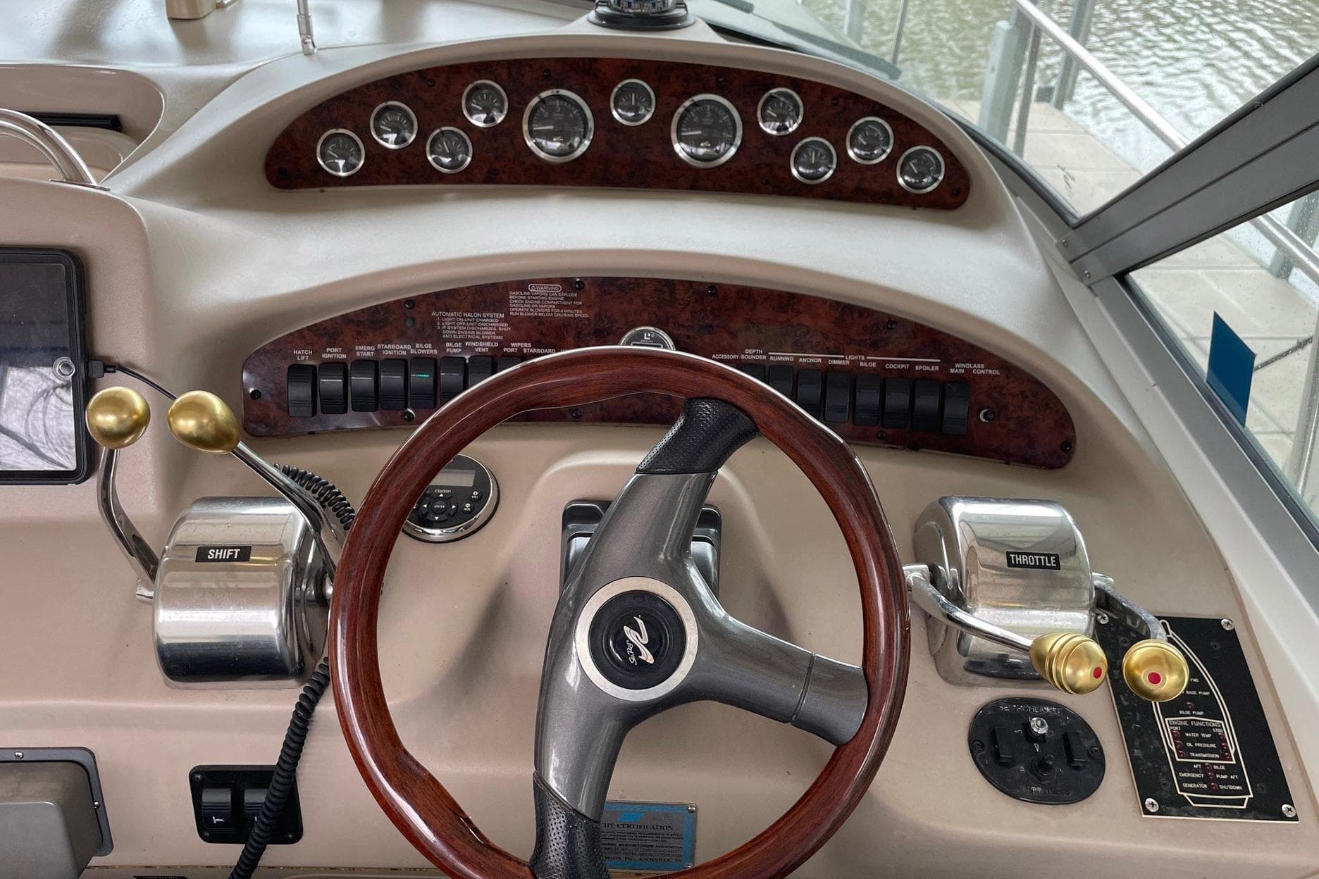 2001 Sea Ray 340 Sundancer helm with steering wheel, gauges, and throttle controls.