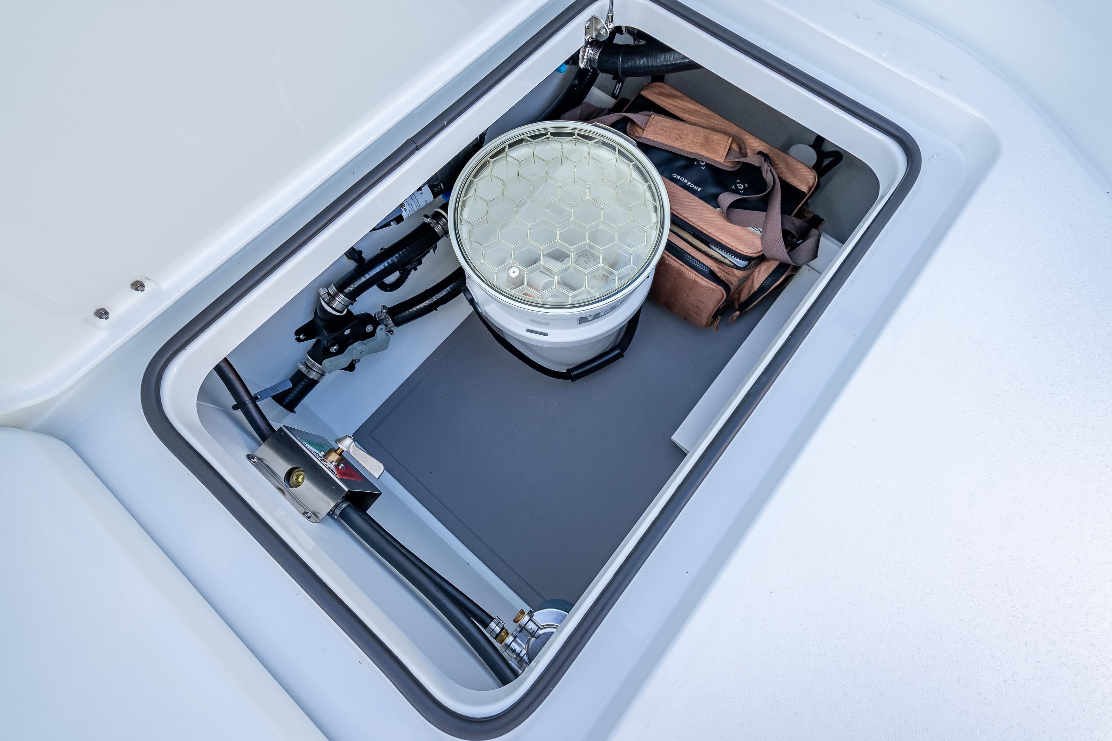 Storage compartment in a 2026 Freeman 35 boat, featuring equipment and a bag.