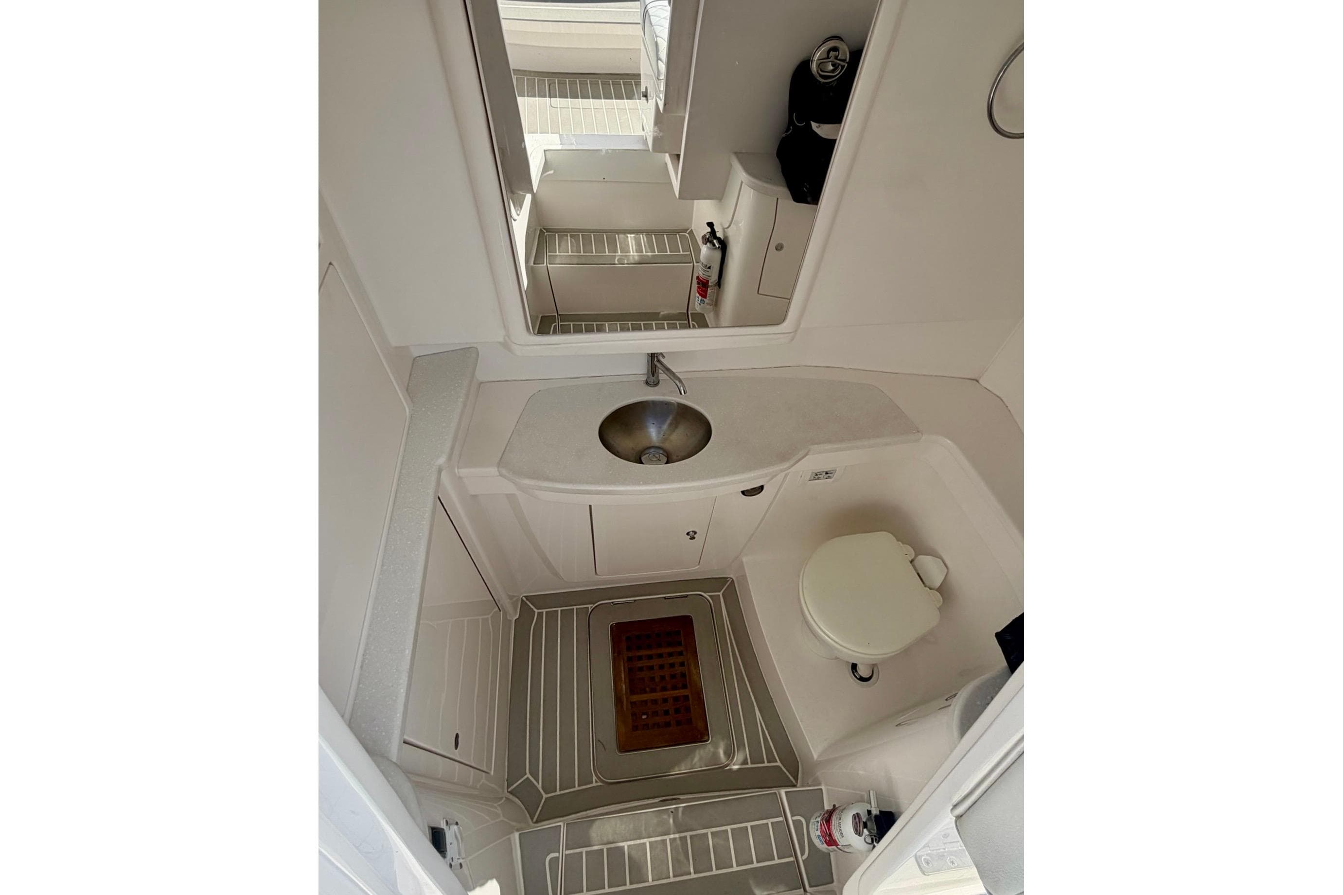 2023 Intrepid 427 Nomad FE boat bathroom with sink, toilet, and mirror.