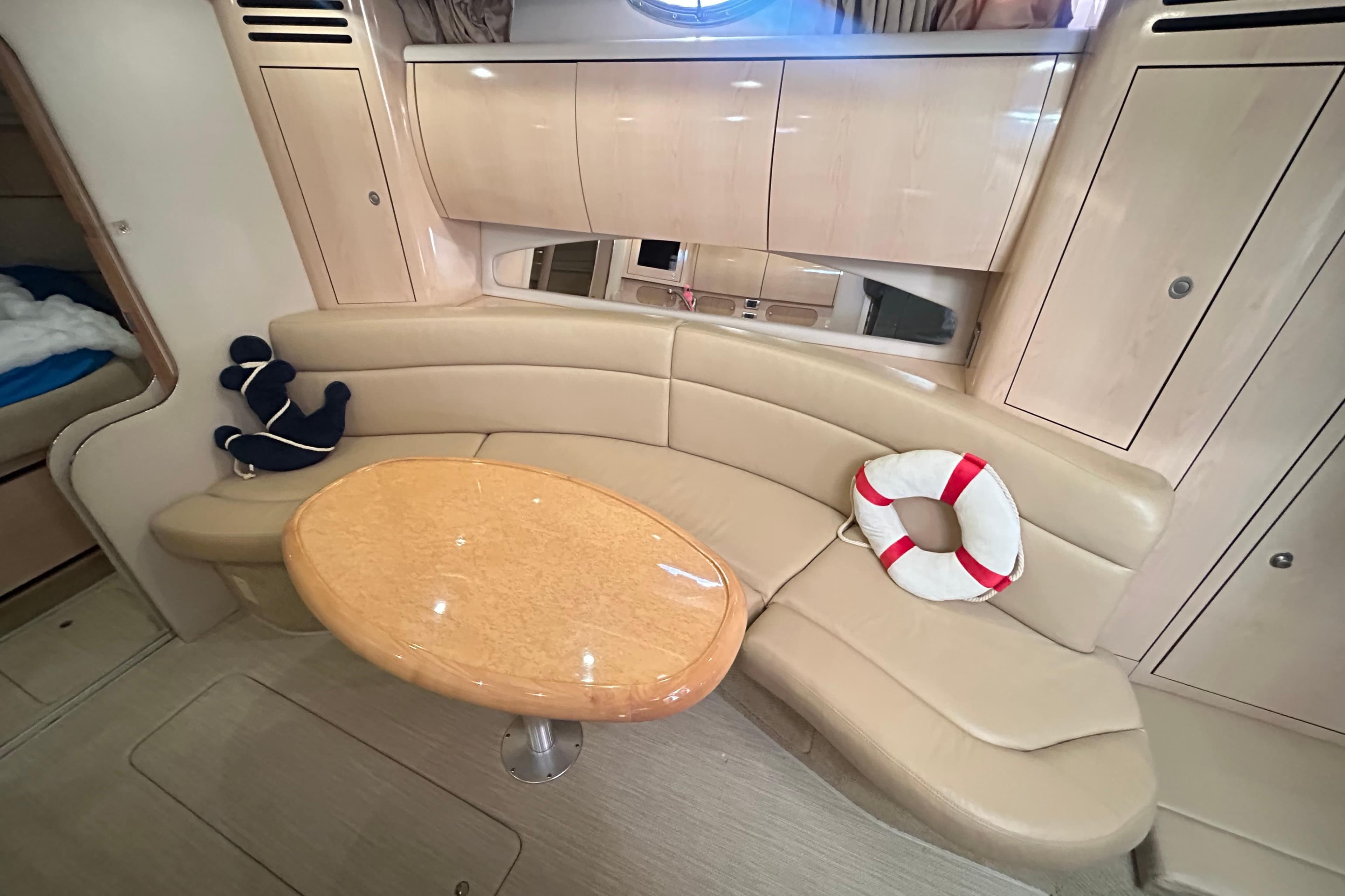 Luxurious interior of 2004 Sea Ray 360 Sundancer with beige seating and wooden table.