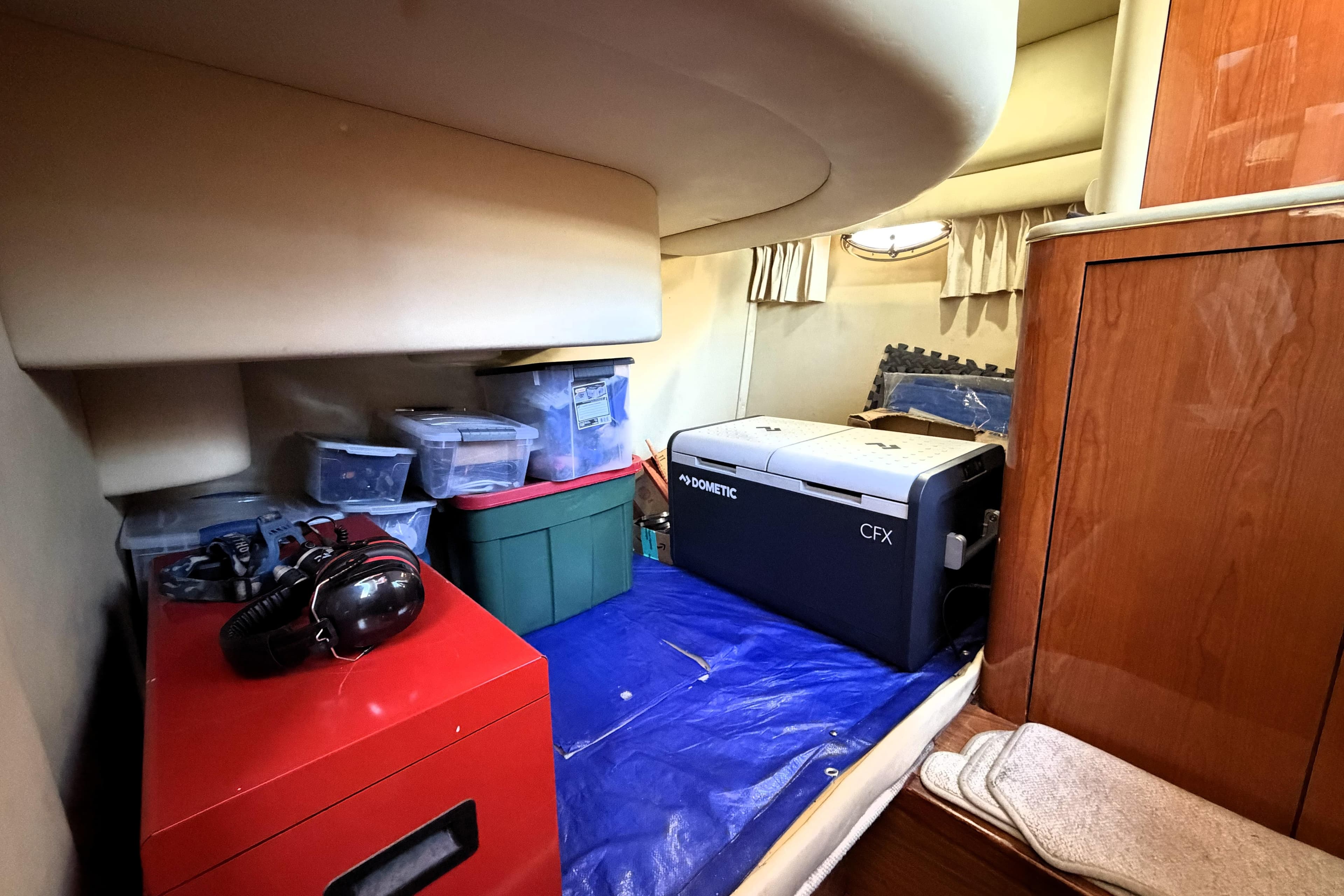 Interior storage area of a 2000 Sea Ray 450 Express Bridge with various containers and equipment.