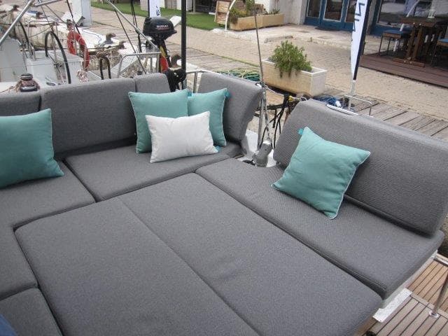 2024 Jeanneau 55 yacht with spacious outdoor seating and teal cushions.