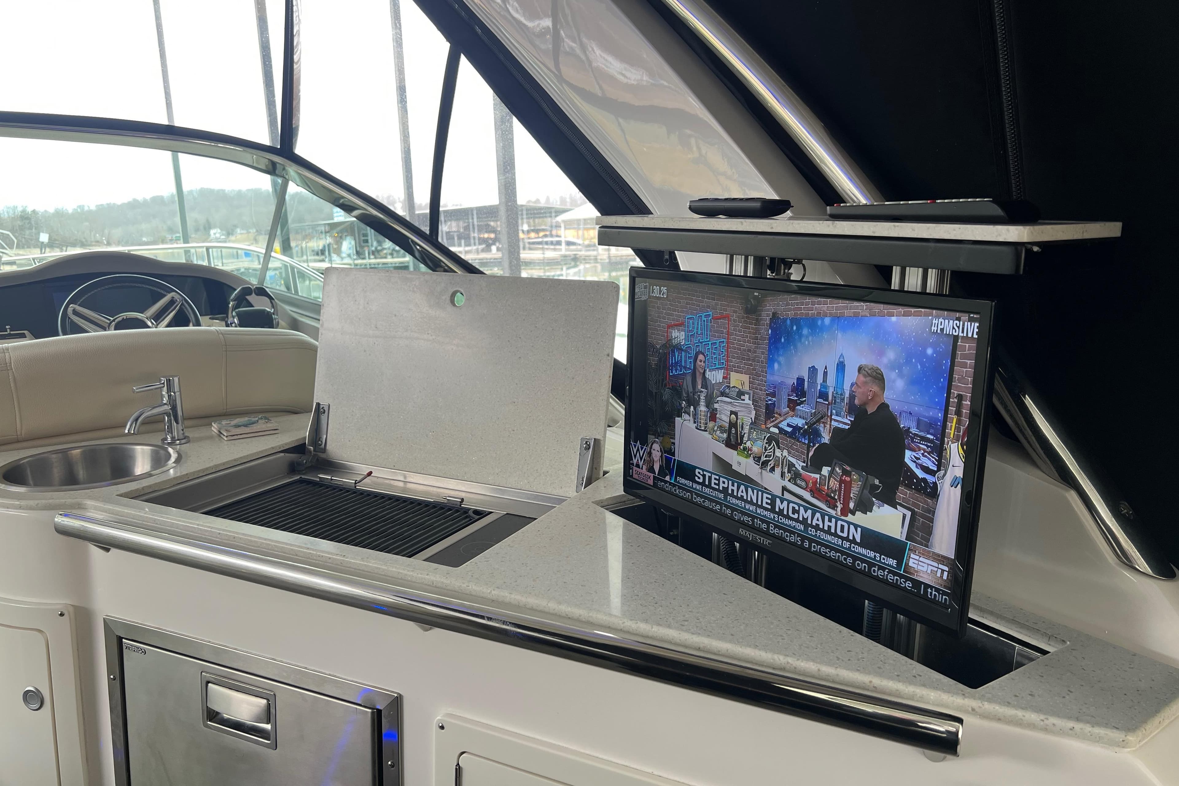 Luxurious 2019 Regal 33 Express yacht interior with TV and kitchenette.