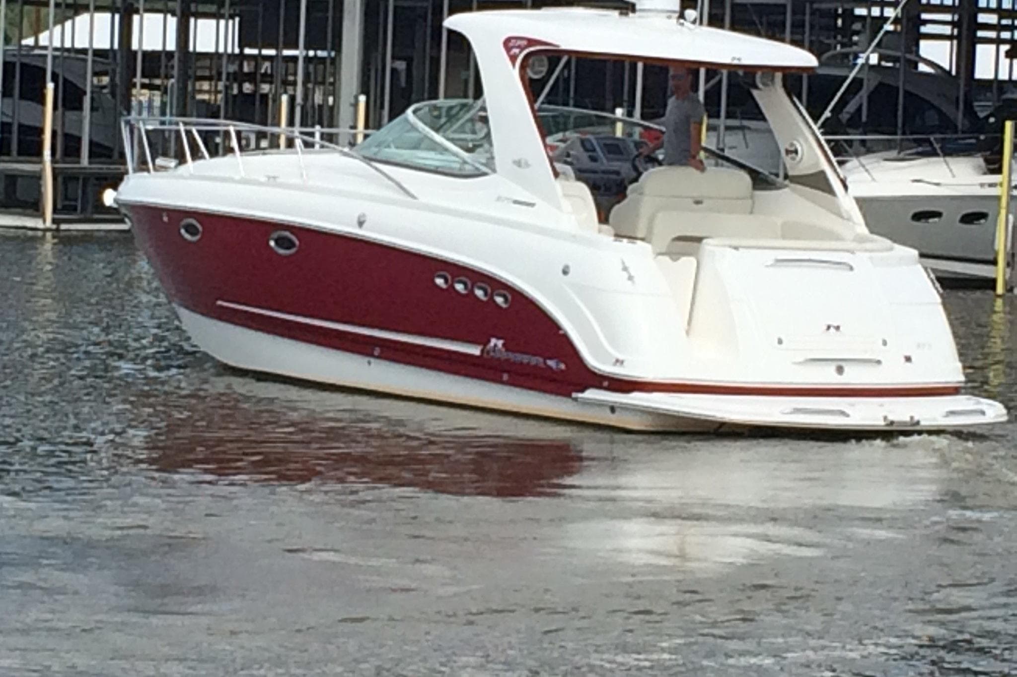 Chaparral Signature 370 boat, 2010 model, docked in marina, red and white design.