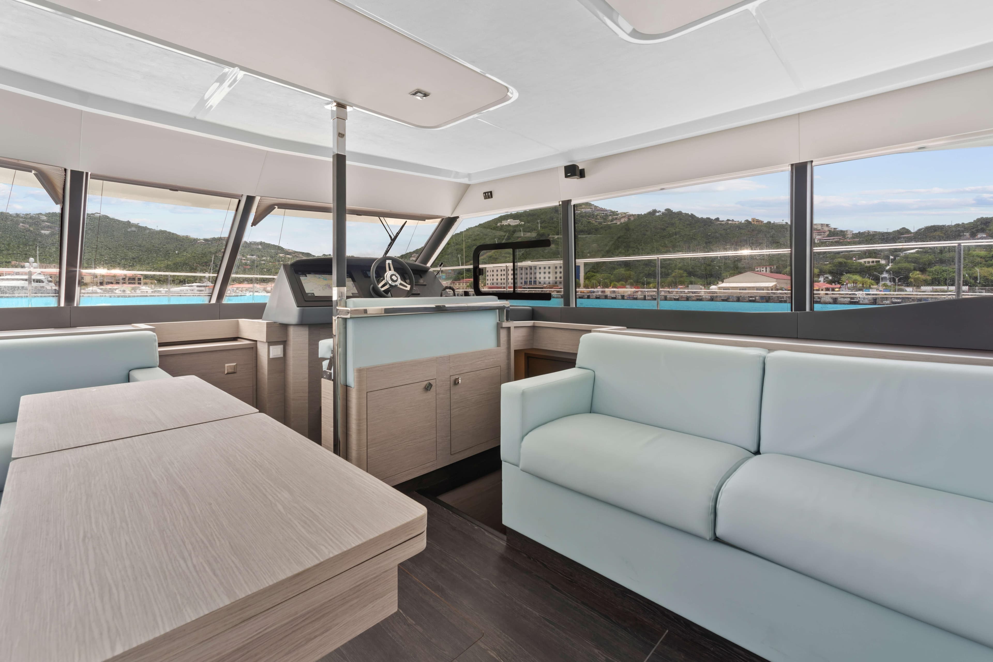 Luxurious interior of 2024 Fountaine Pajot MY6 yacht with modern seating and panoramic windows.