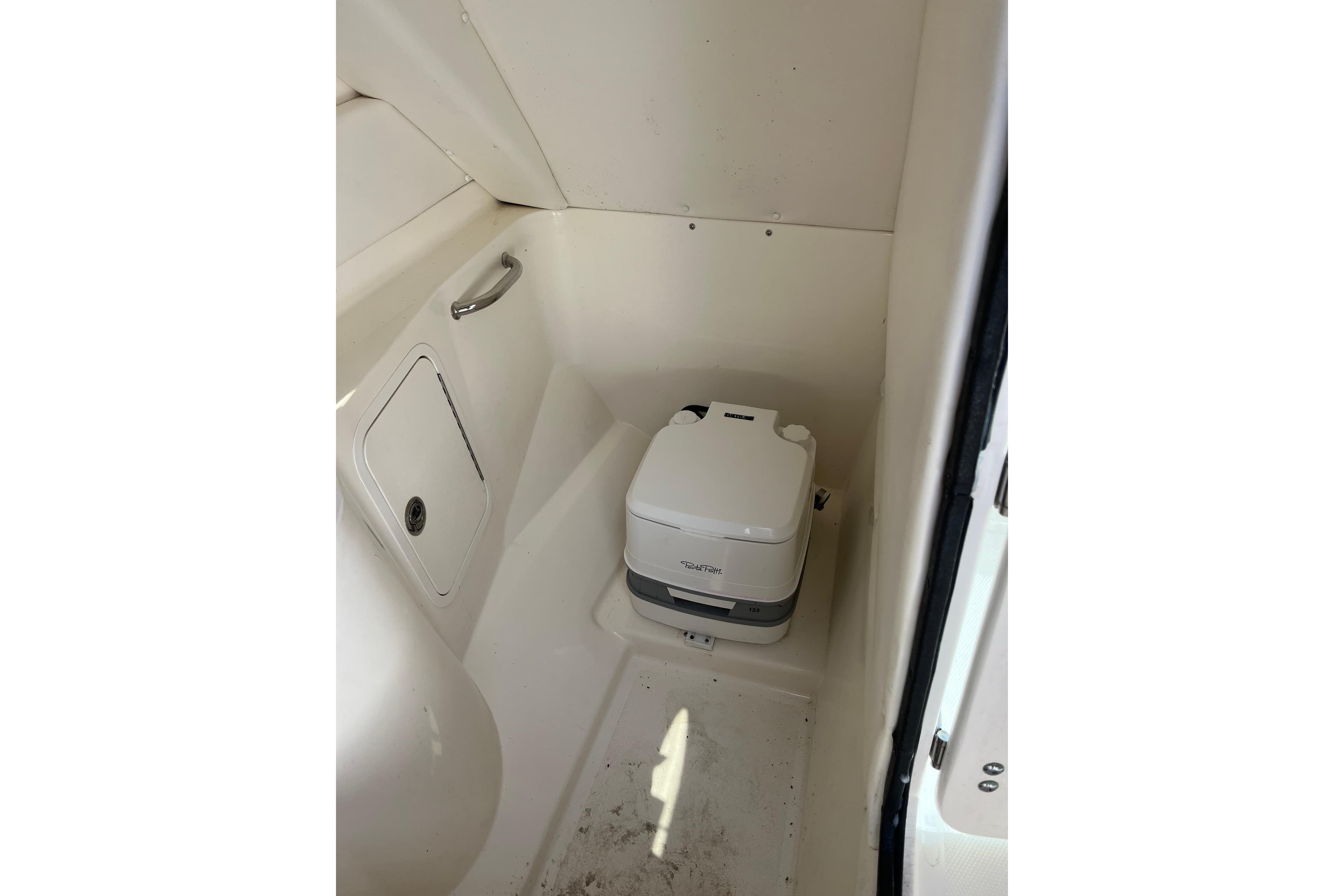 Interior of 2011 Sea Ray 260 Sundeck featuring a compact marine toilet.