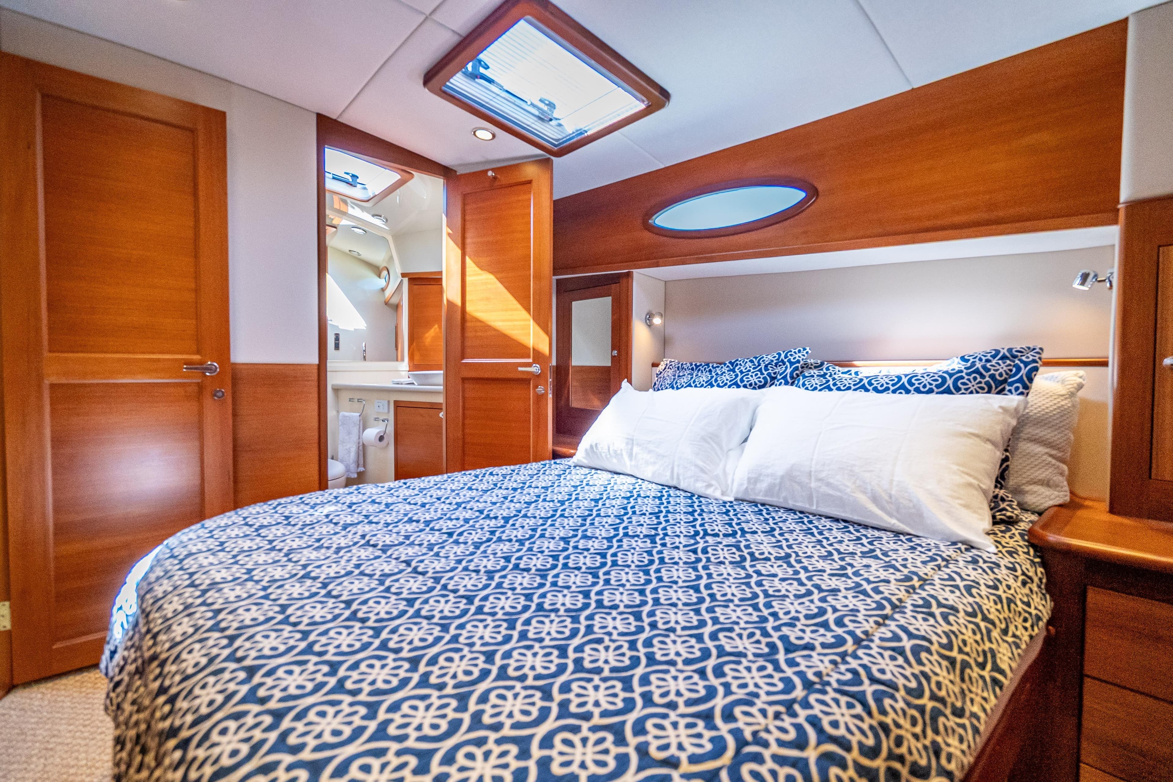 Luxurious cabin interior of 2018 Palm Beach Motor Yachts PB55 with elegant bedding and wood finishes.