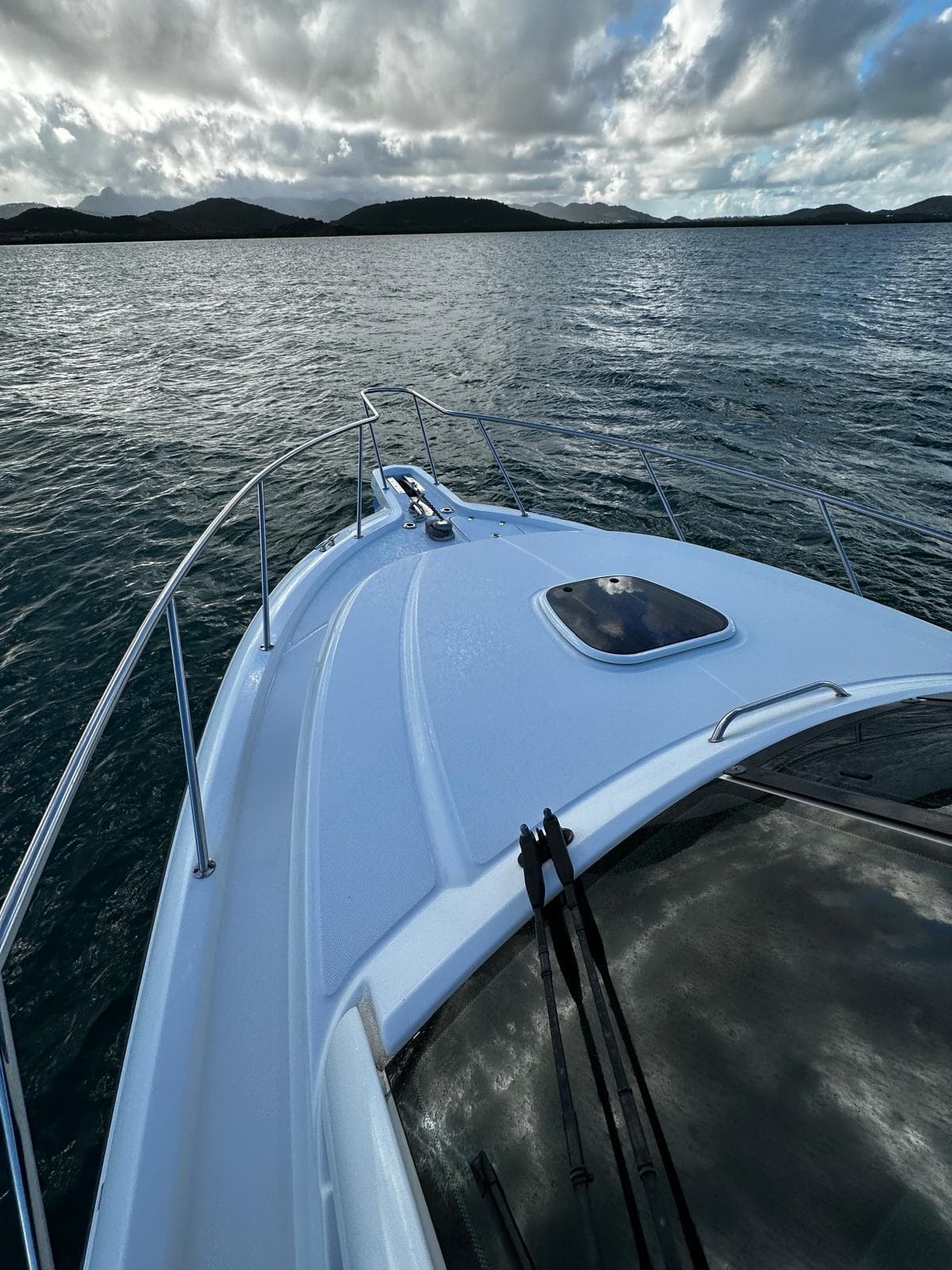 Boston Whaler 345 Conquest 2015 cruising on serene waters under a cloudy sky.