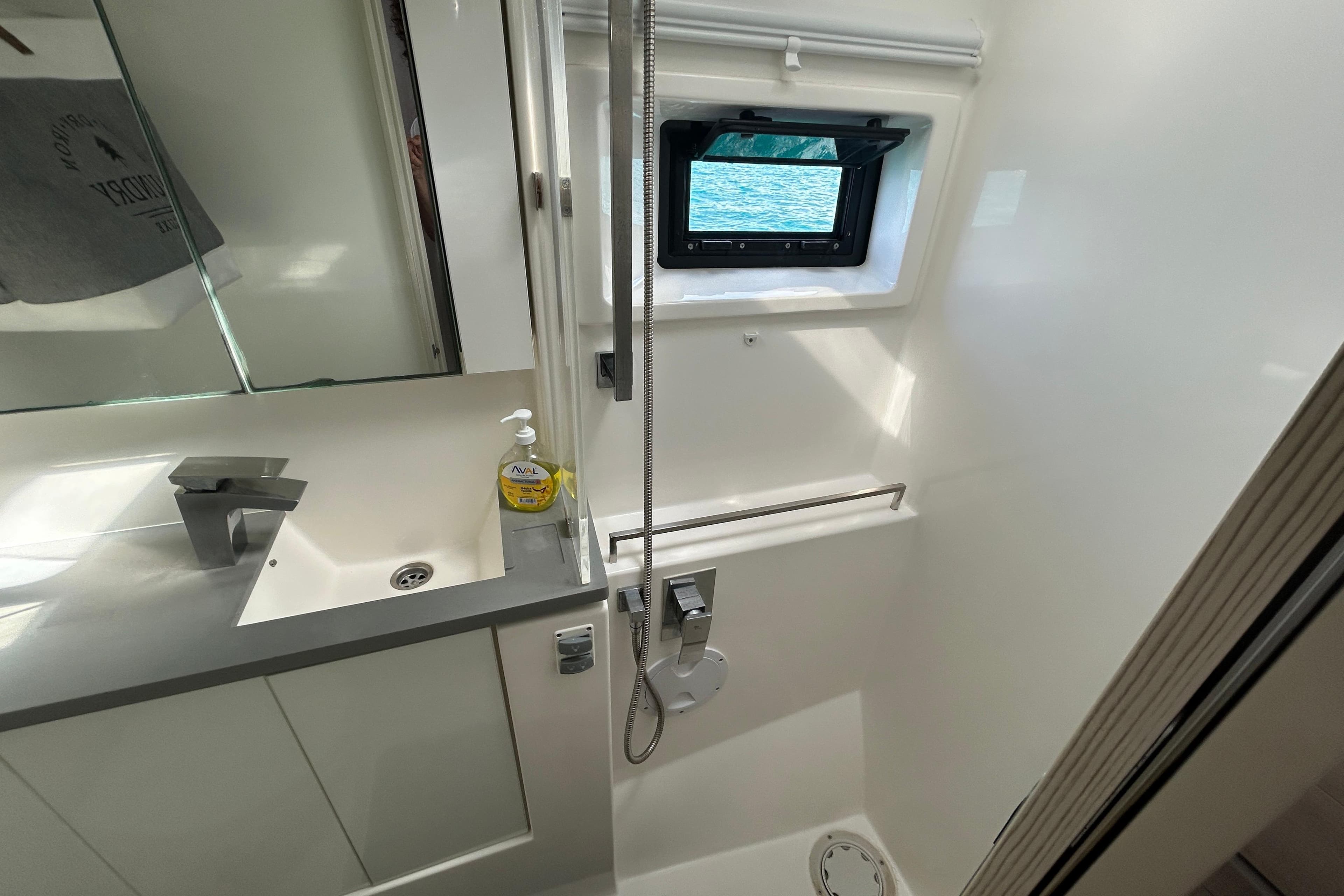 Modern bathroom in a 2020 Leopard 45 yacht with sleek fixtures and a small window.