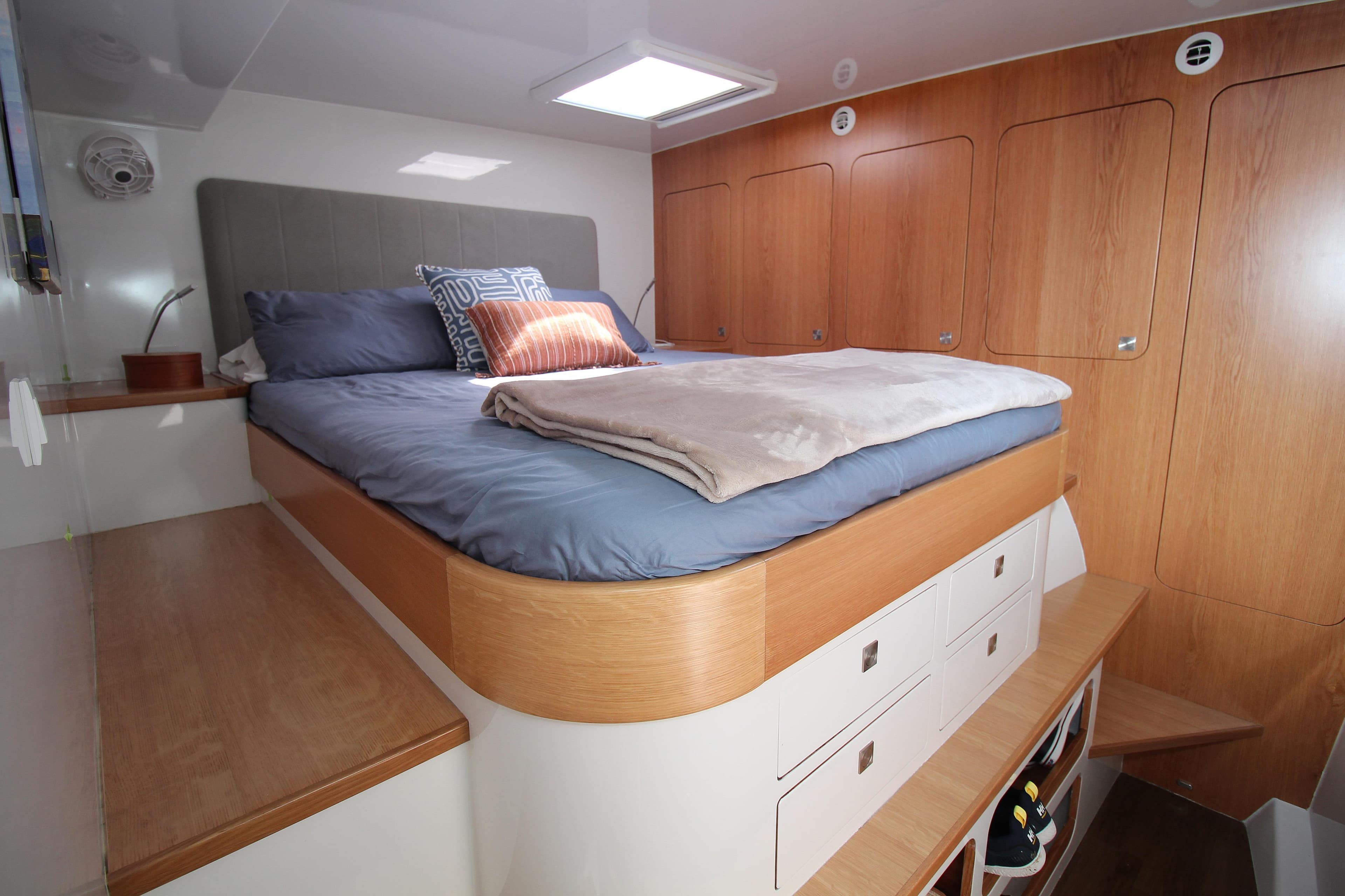 Luxurious cabin interior of 2026 Chris White Spindrift 47 yacht with cozy bed and wooden storage.