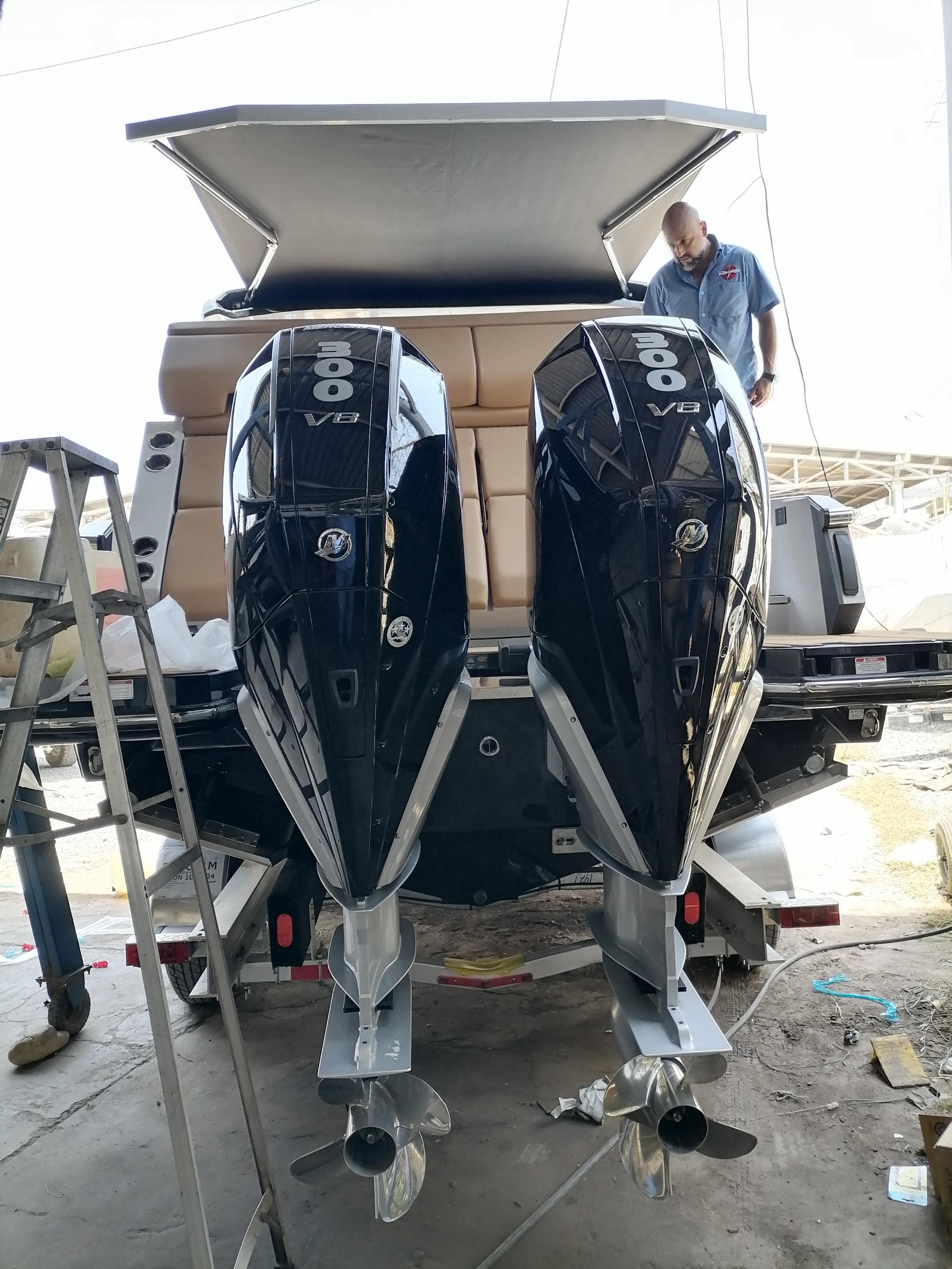 2024 Aviara AV32 OB boat with twin V8 outboard engines, docked and under maintenance.