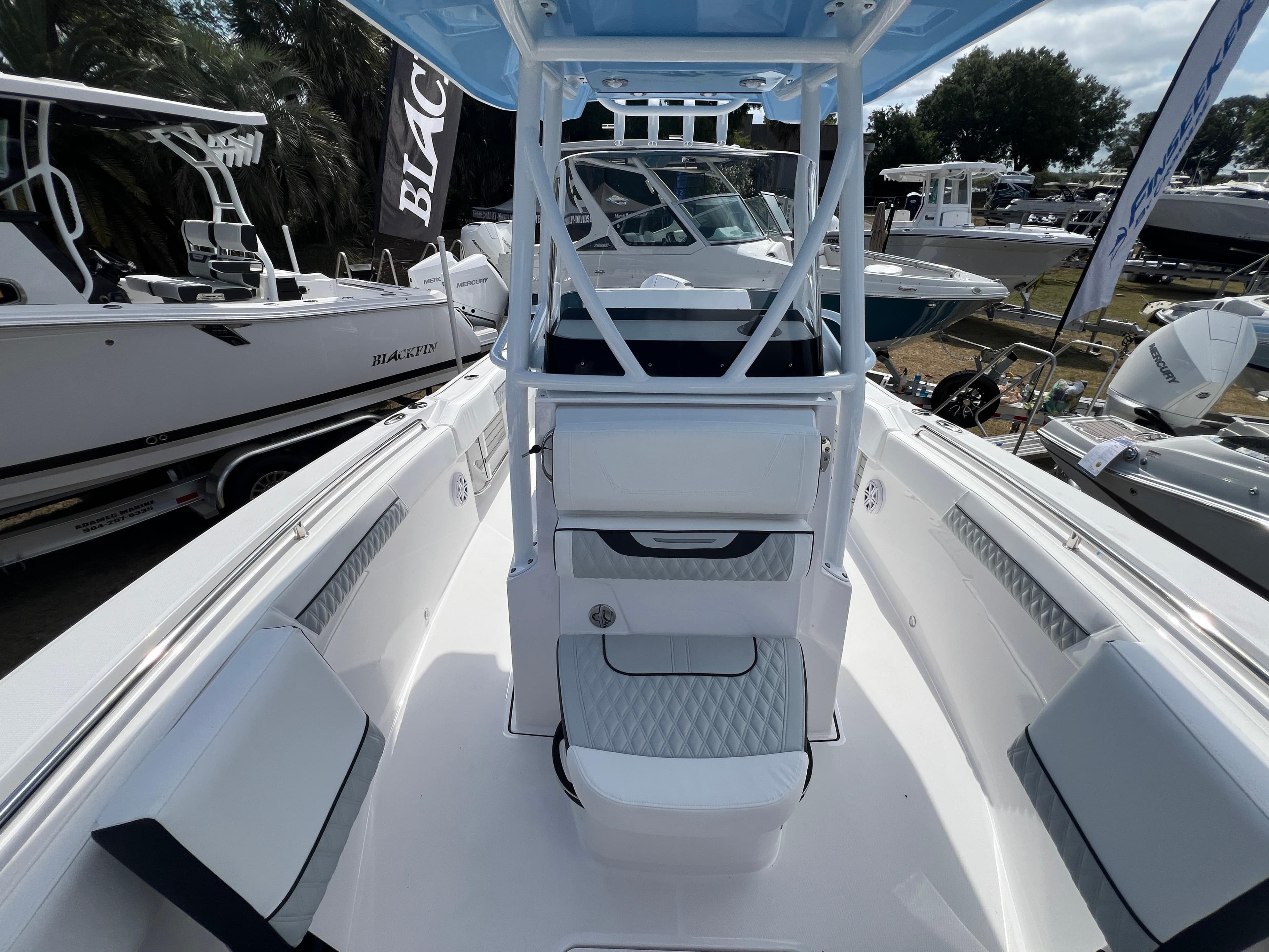 2025 Blackfin 222 CC boat interior with seating and console, displayed at a boat show.