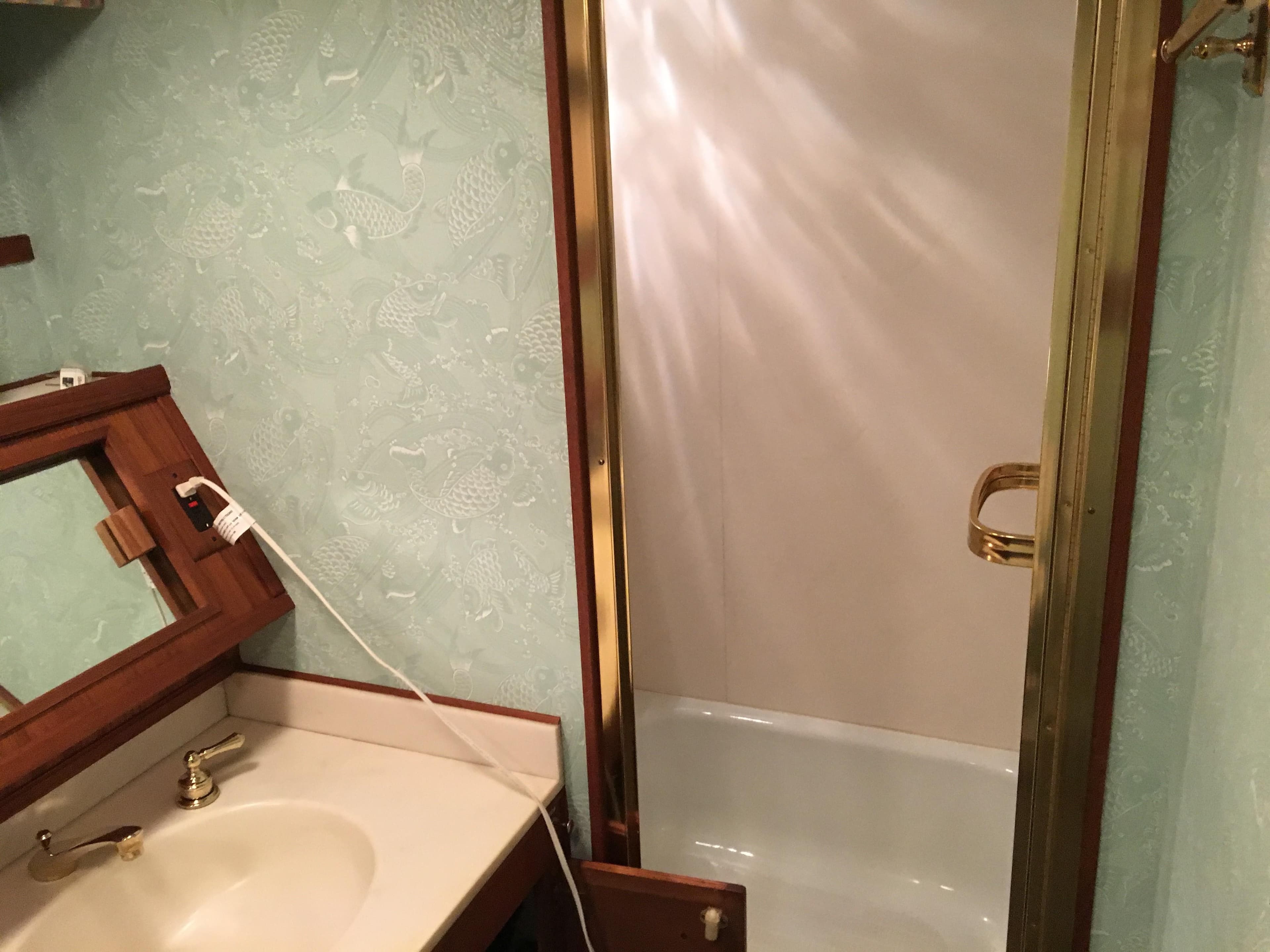1984 Chris-Craft Constellation bathroom with sink, mirror, and shower.