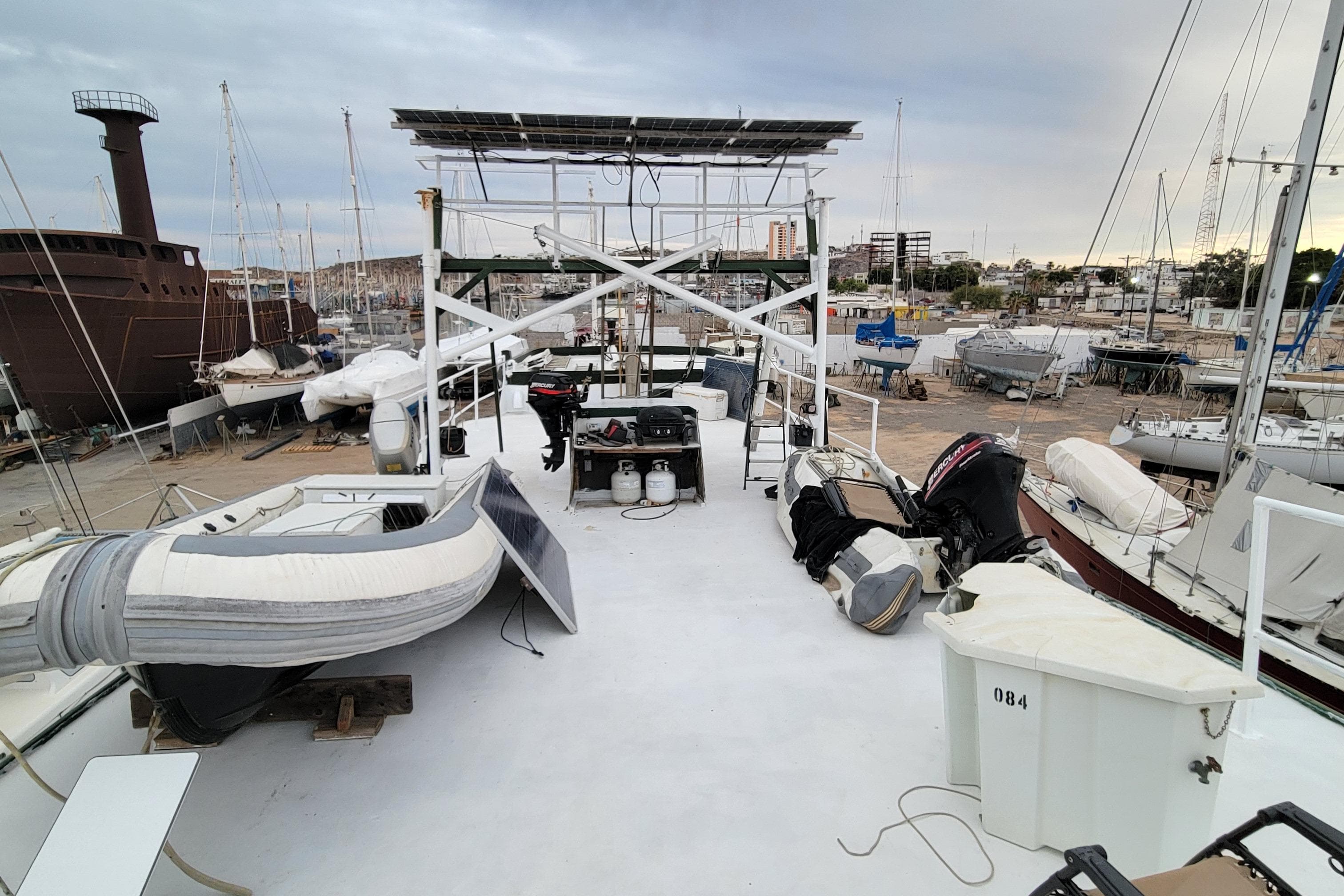 1979 Shrimper Conversion Trawler on dry dock with equipment and boats nearby.