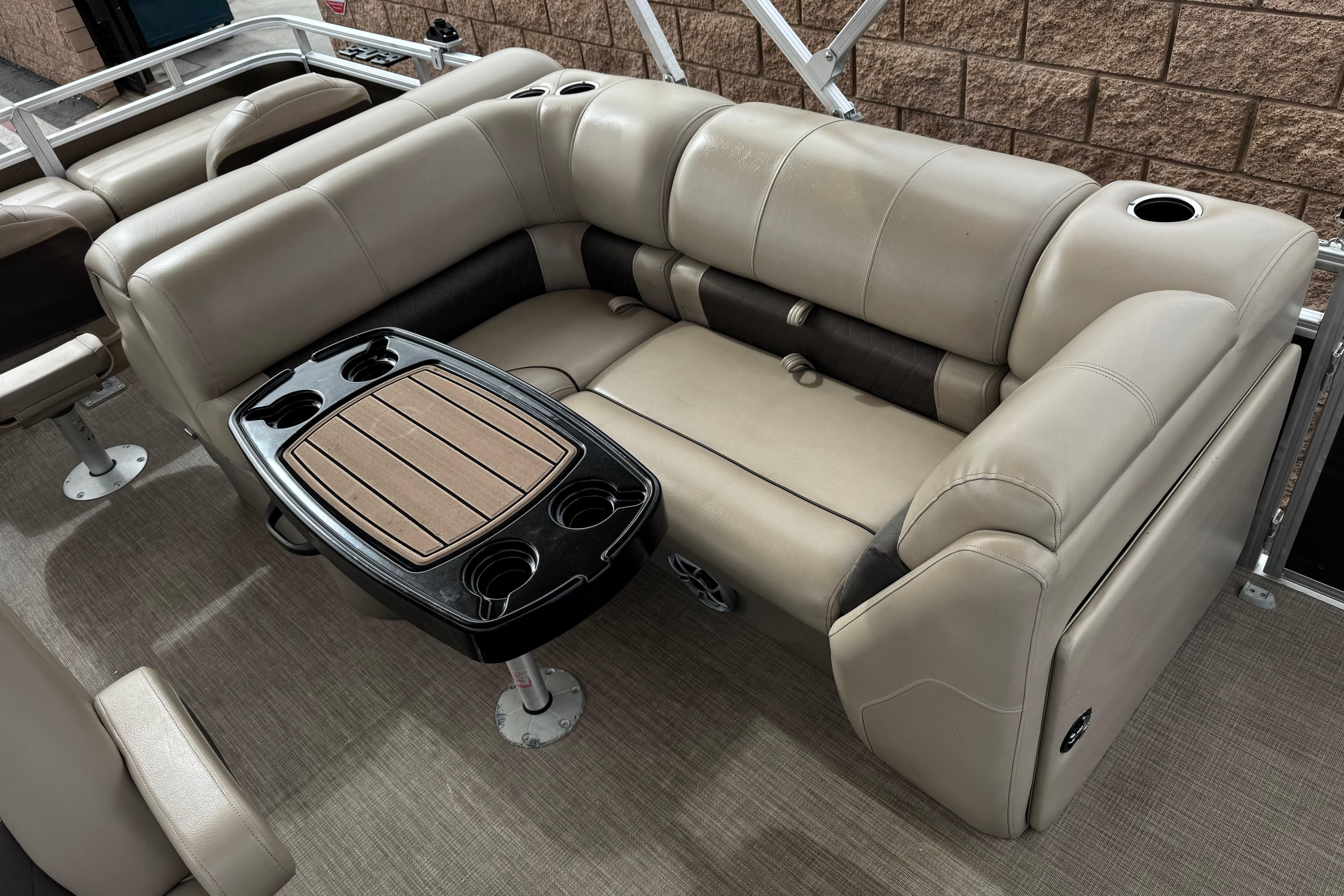 2024 Sun Tracker SportFish 22 DLX interior with beige seating and a central table.