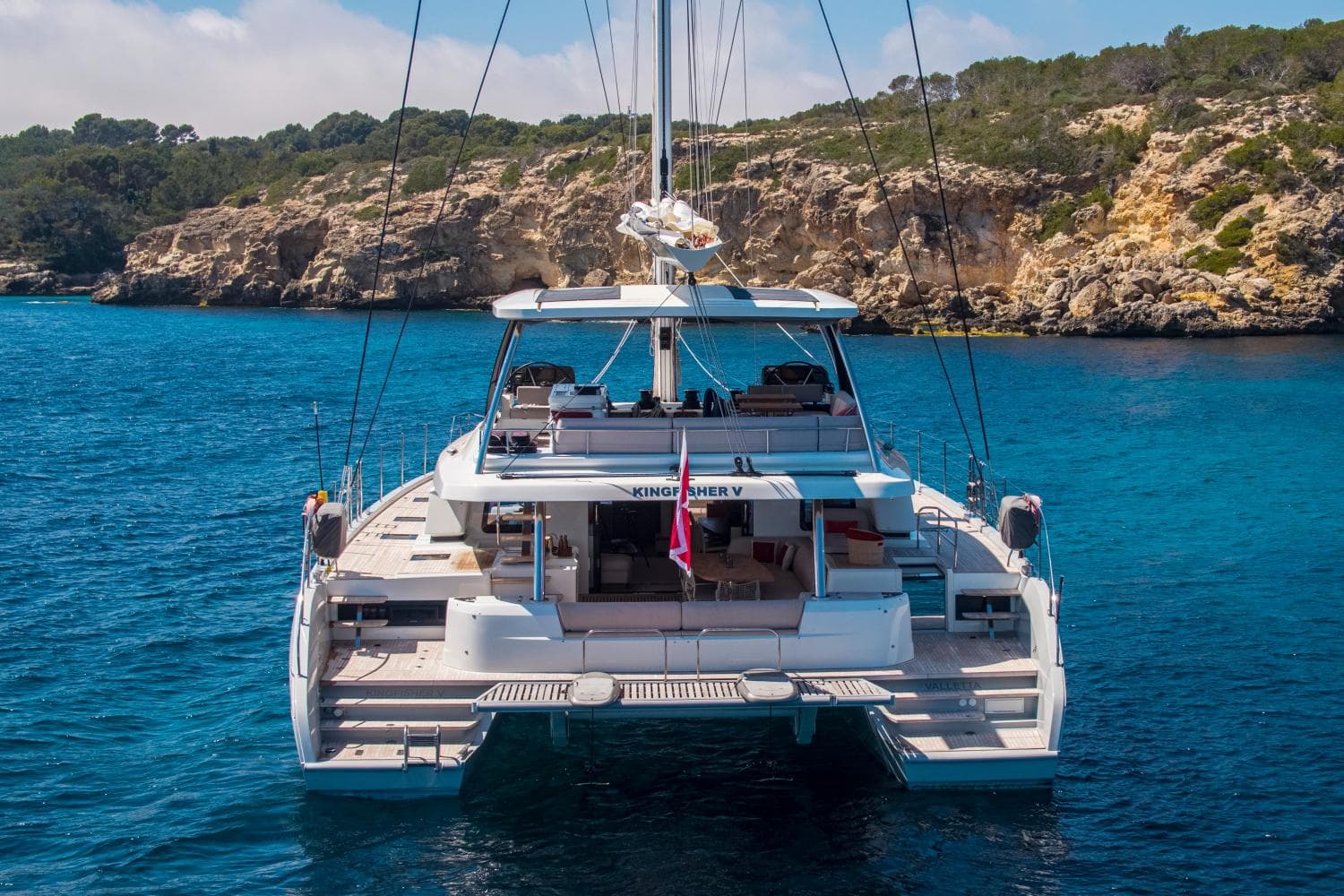 Luxury Lagoon SIXTY 5 catamaran anchored in scenic coastal waters, 2021 model.