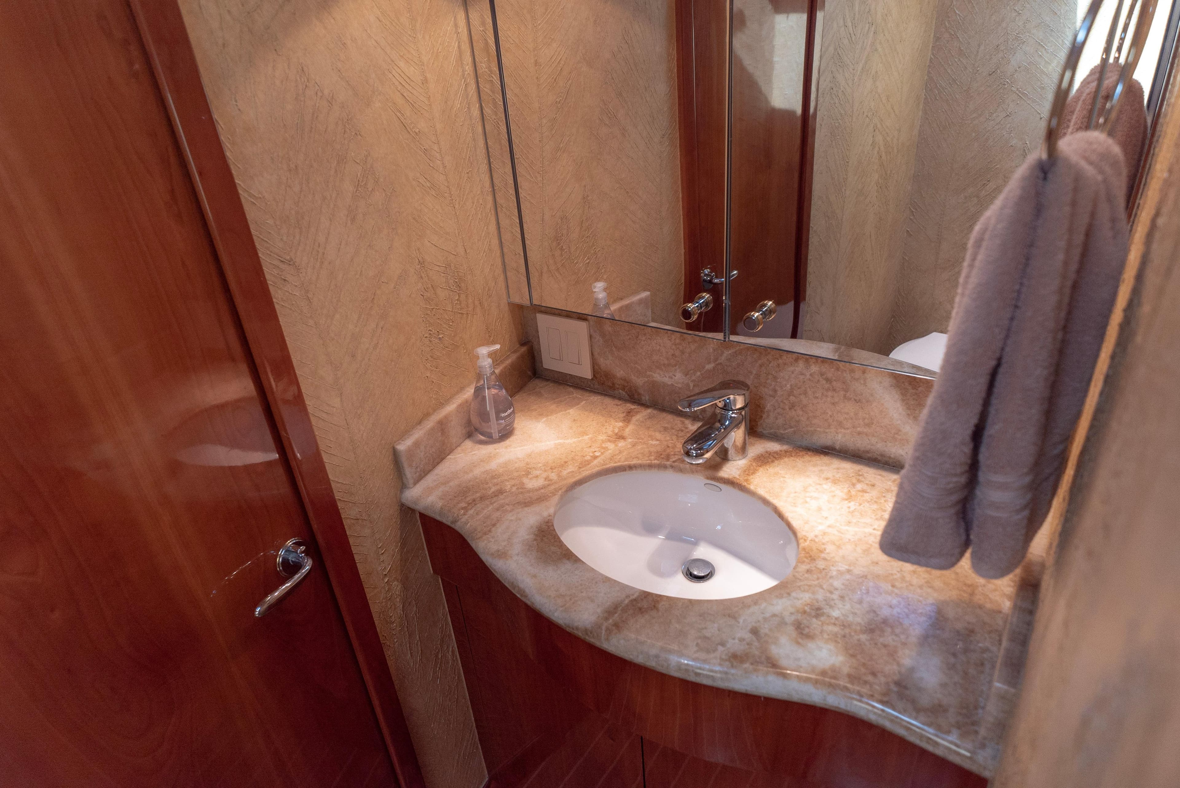 Luxurious bathroom in 2003 Hatteras 70 Convertible yacht with marble countertop.