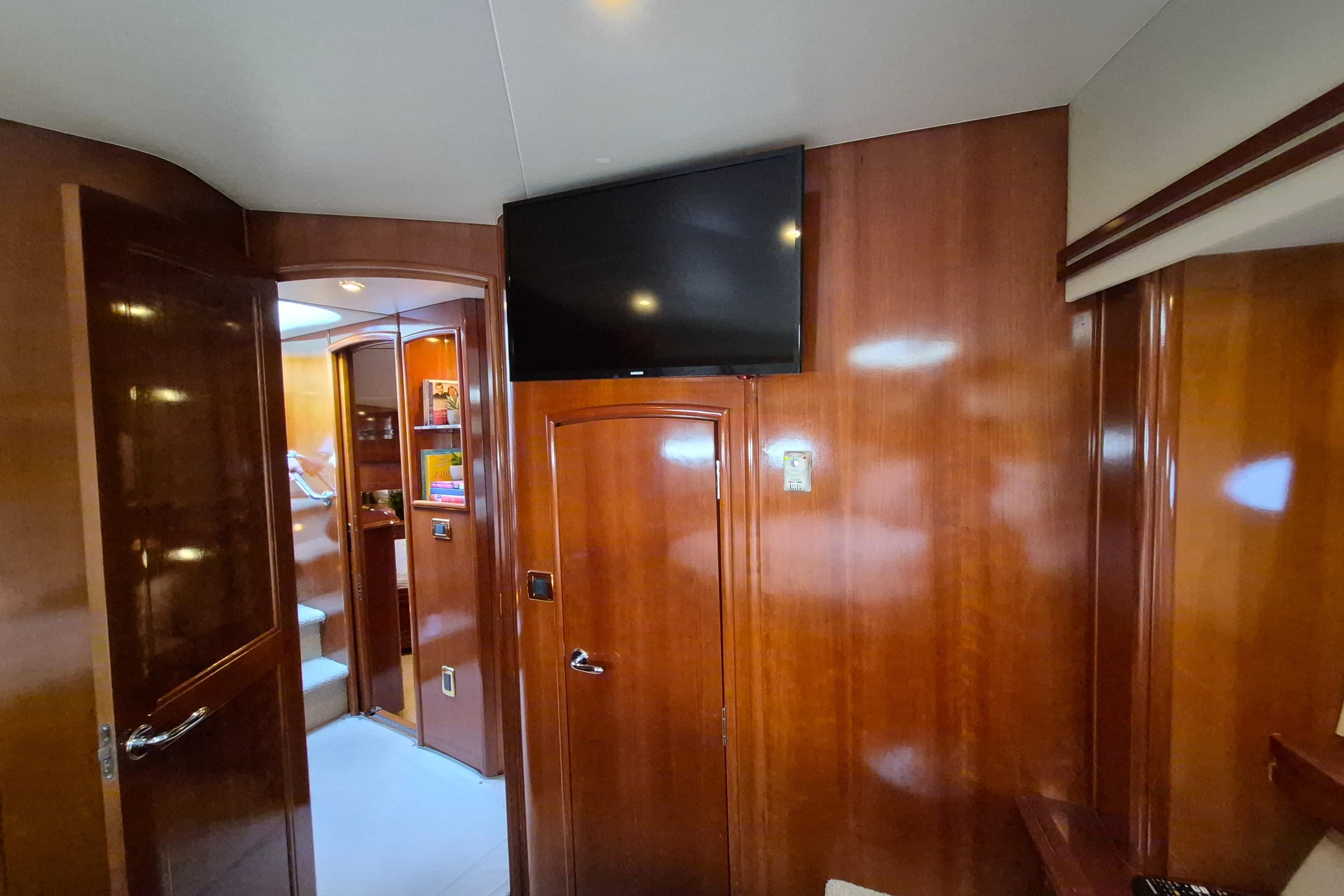 Interior of 2005 Carver 560 Voyager yacht with wood paneling and mounted TV.