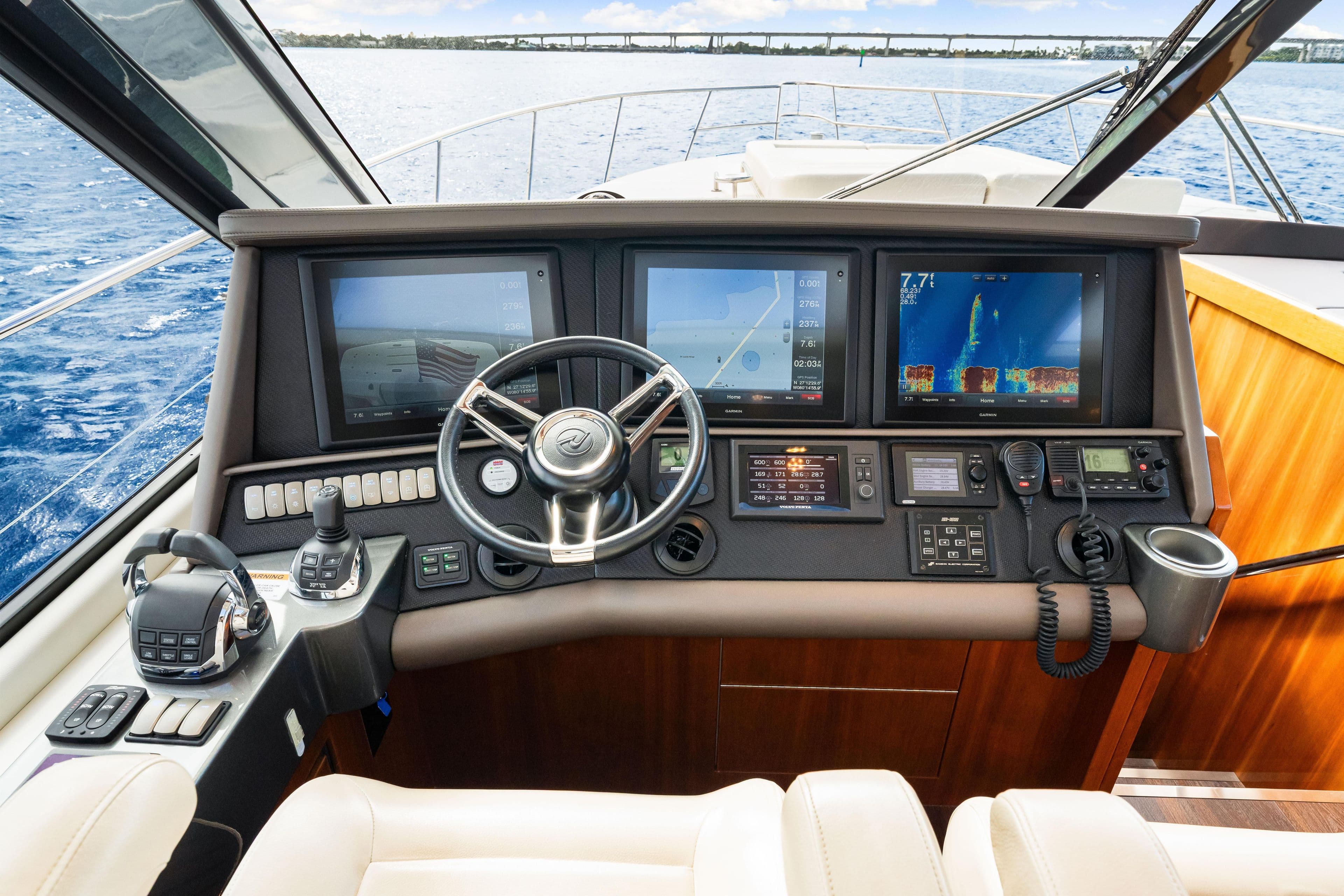 Control panel of 2015 Riviera 565 SUV yacht with navigation screens and steering wheel.