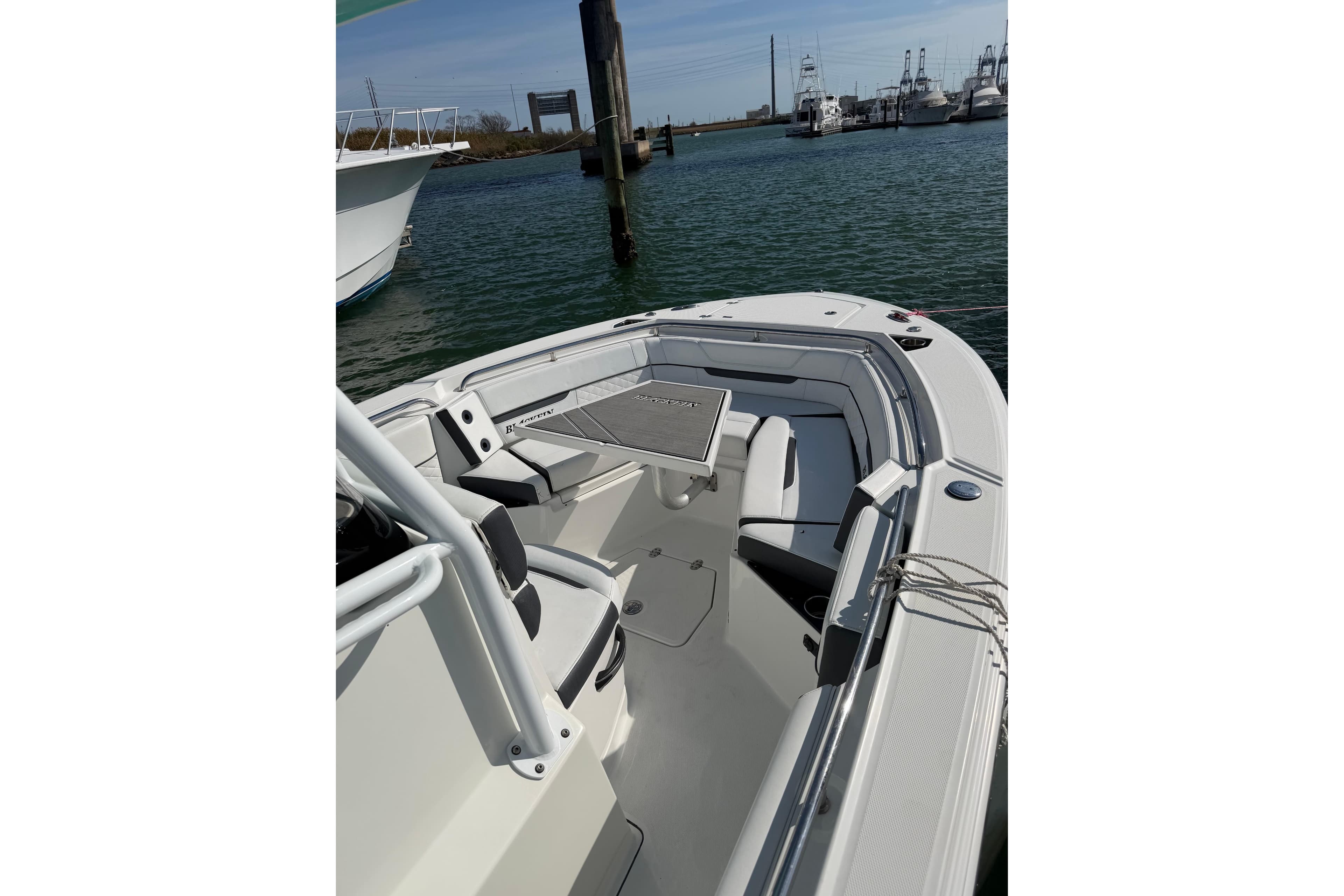 2021 Blackfin 252 CC boat docked in a marina, showcasing spacious seating and sleek design.