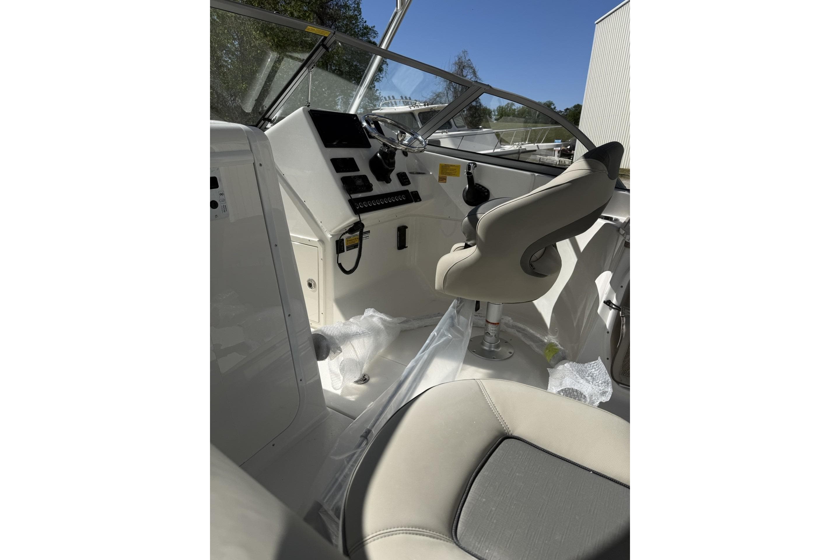 Interior view of 2026 Key West 239 DFS boat cockpit with steering wheel and seating.