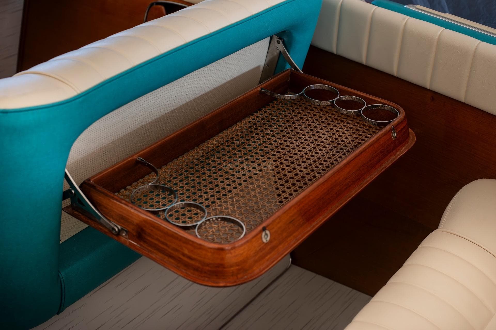 Vintage 1967 Riva Aquarama boat interior with wooden tray and turquoise seating.