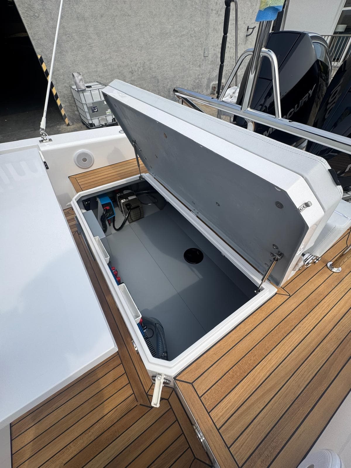 Open storage compartment on 2026 Pirelli 30 boat with wooden deck.