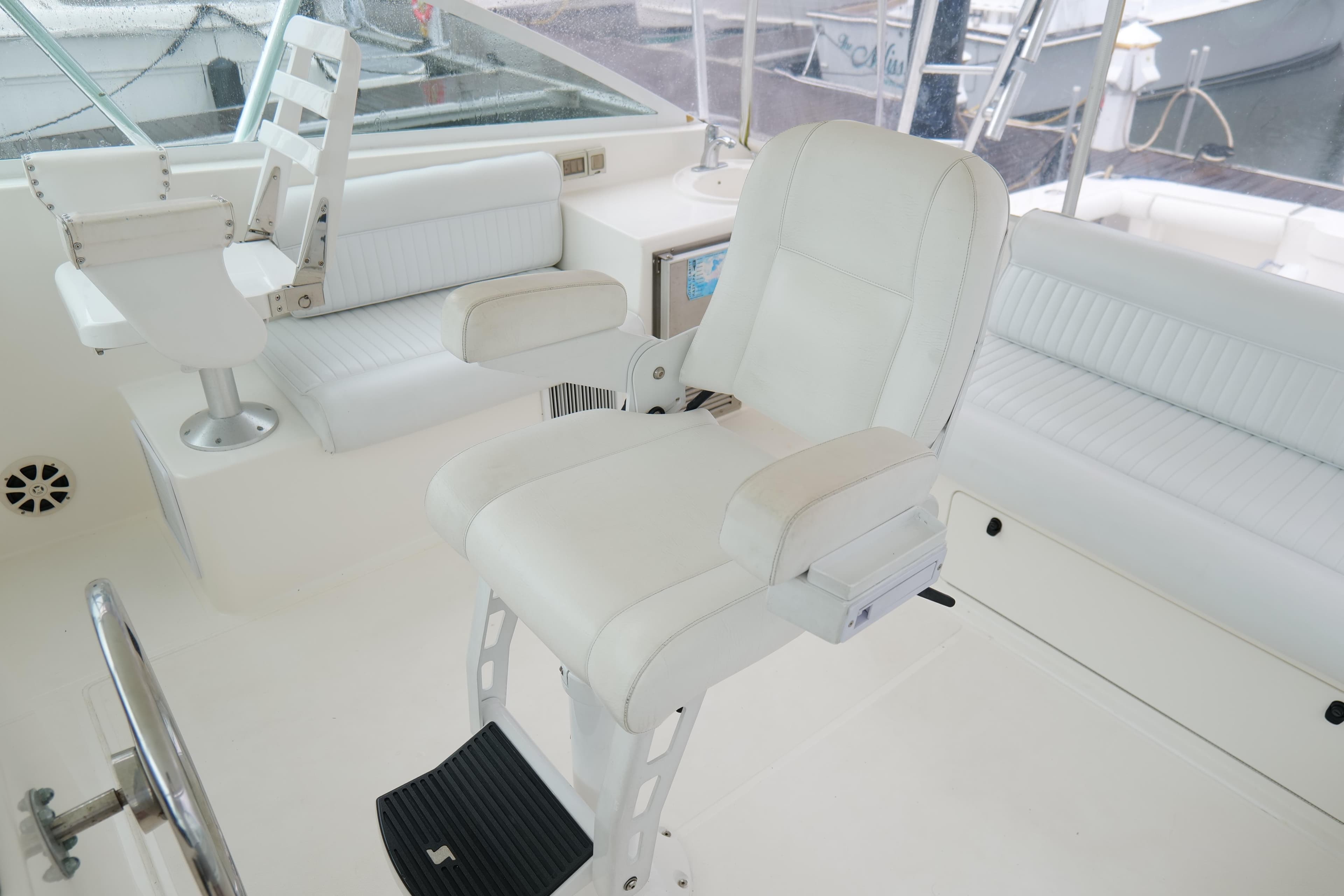 Luxurious white seating on a 1998 Cabo 45 Express yacht's helm area.