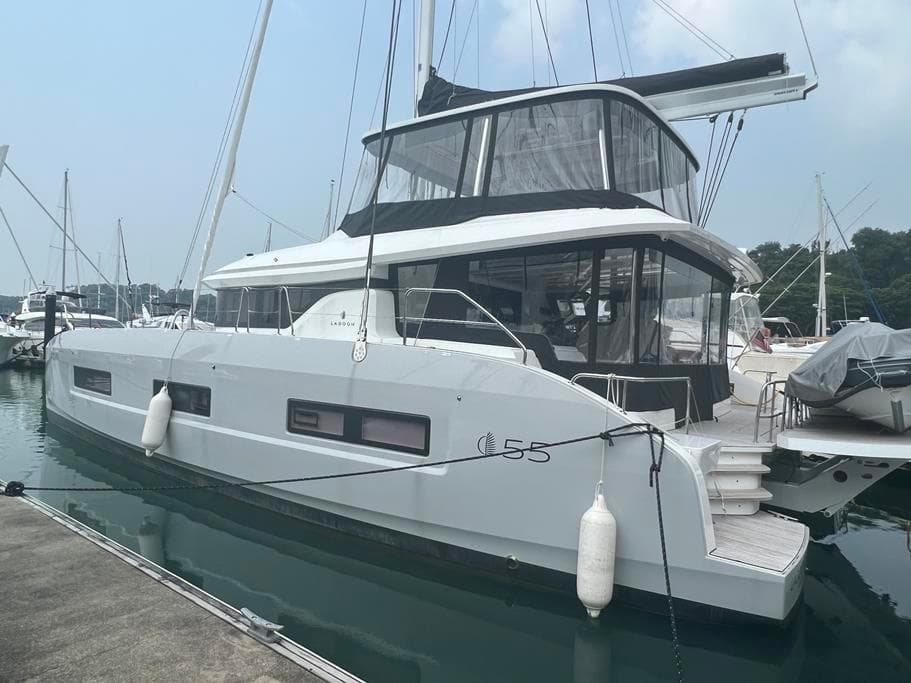 2023 Lagoon 55 catamaran docked at marina, featuring sleek design and modern amenities.